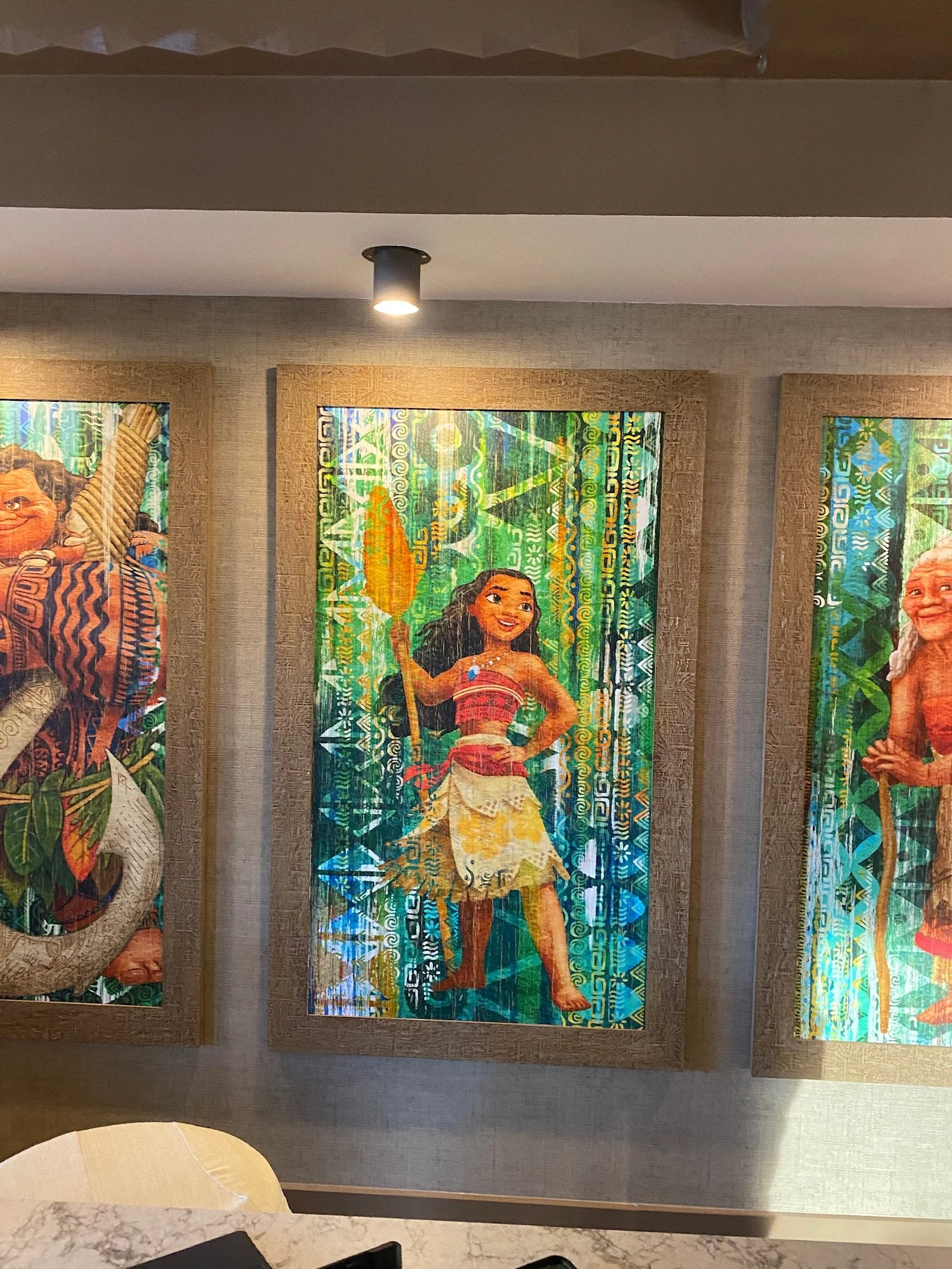 Colorful wall art featuring Moana, the Disney character, holding a paddle, in a Polynesian-inspired background.