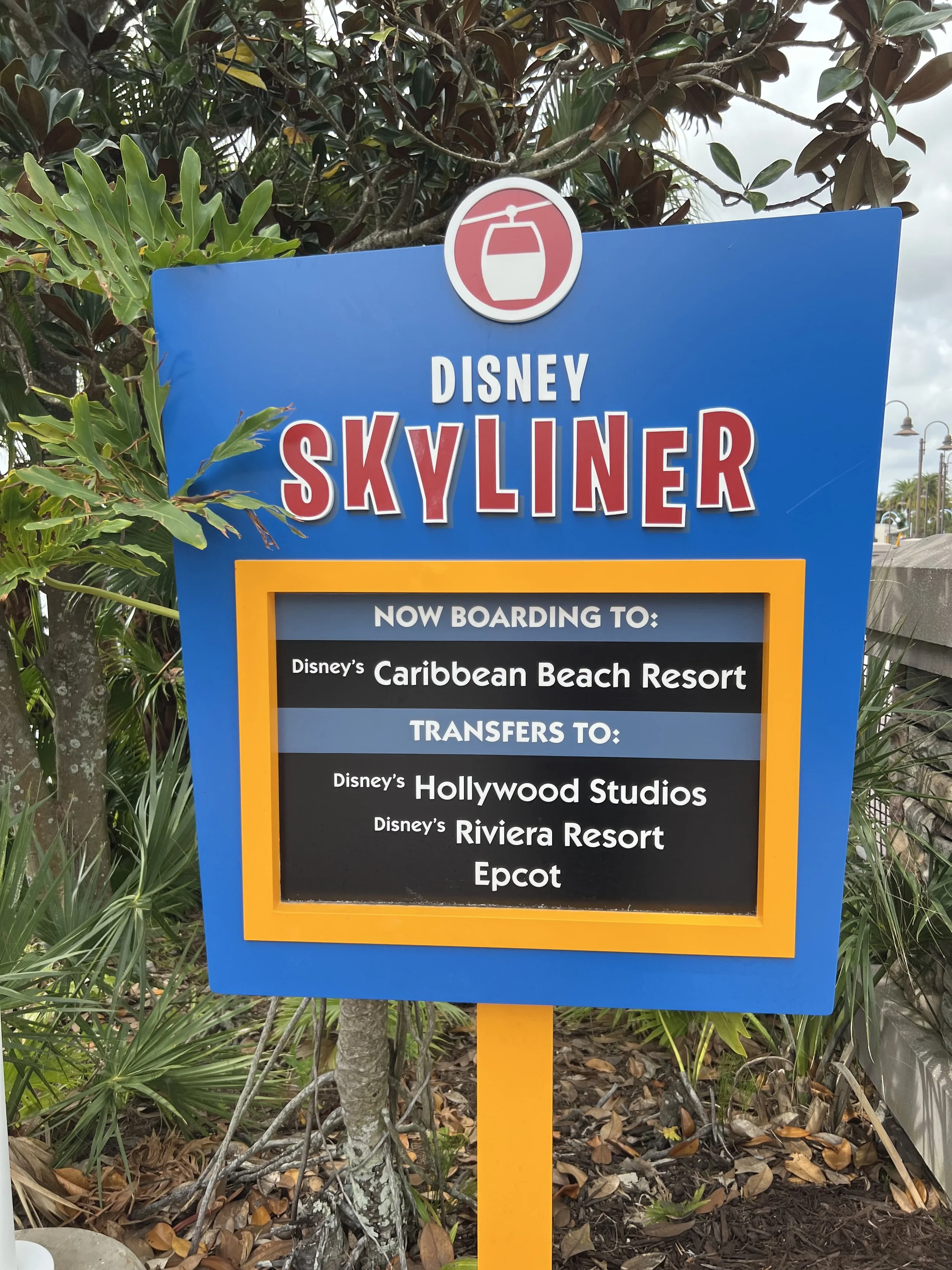 Disney Skyliner sign with directions to Caribbean Beach Resort, Hollywood Studios, Riviera Resort, and Epcot.