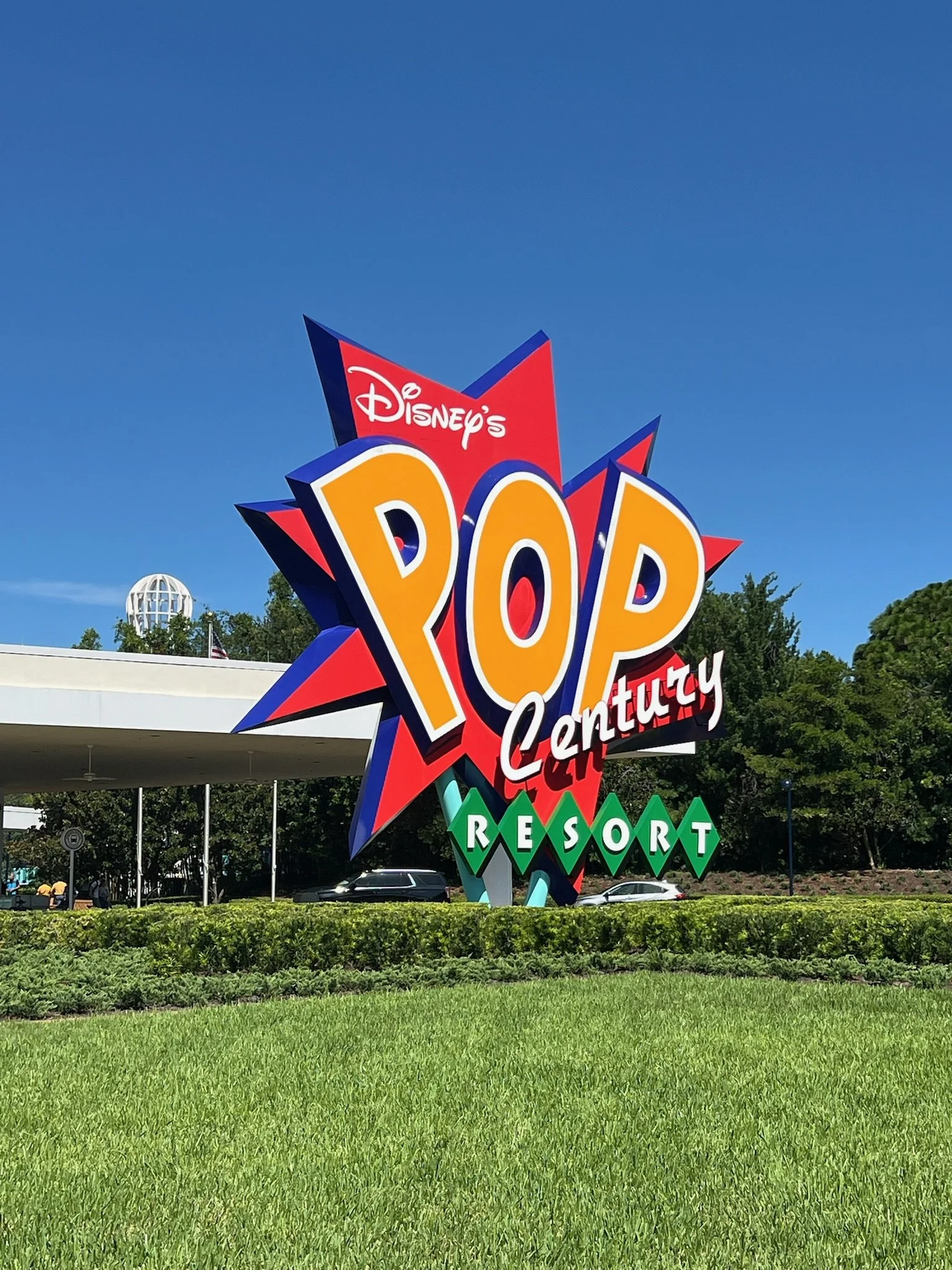 Colorful sign for Disney's Pop Century Resort with a starburst design, large yellow letters spelling 'POP,' and the words 'Century' and 'Resort' beneath.