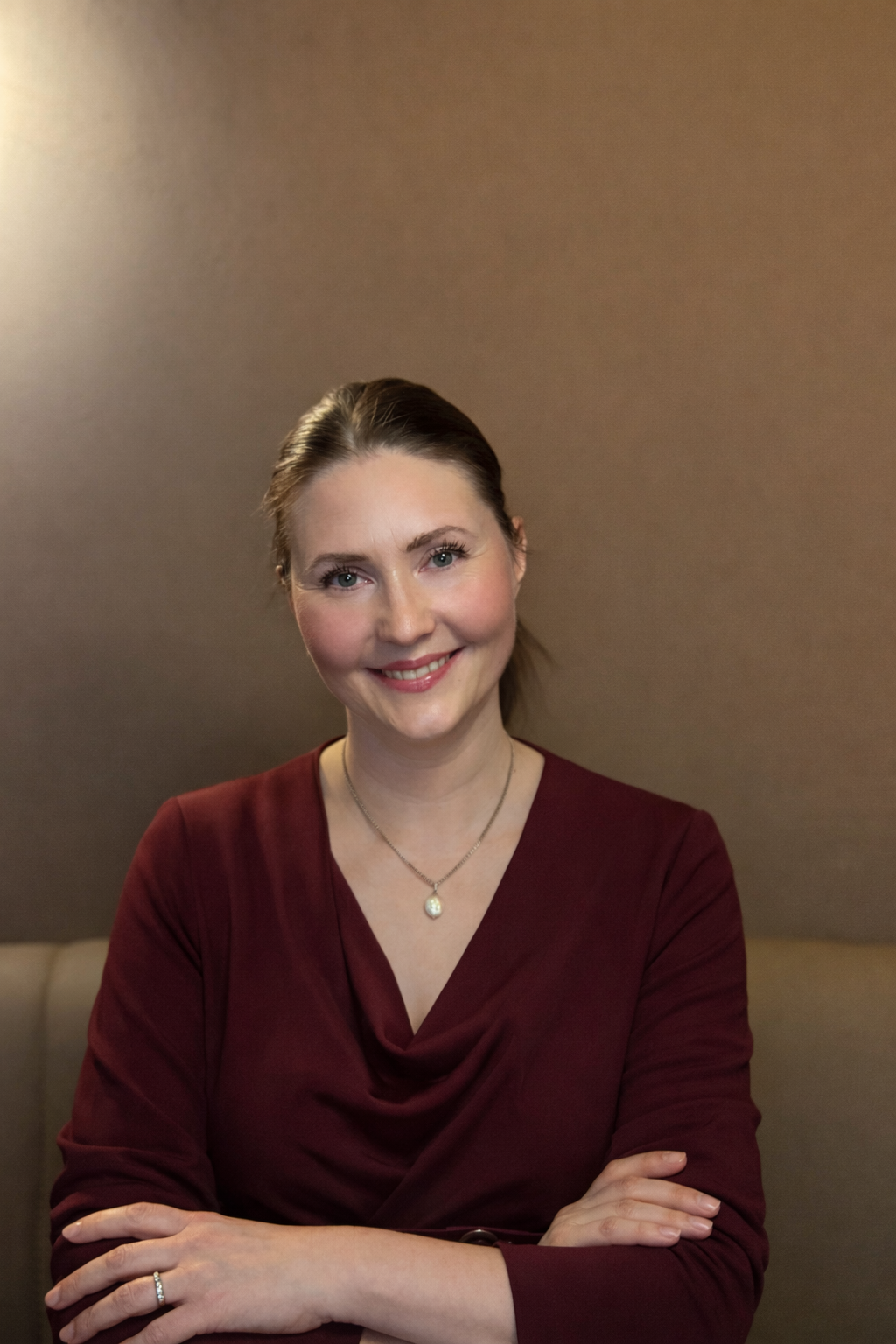 Et portrett av en smilende Dr. Lisbeth Kjernli, iført en mørkerød kjole og smykker.