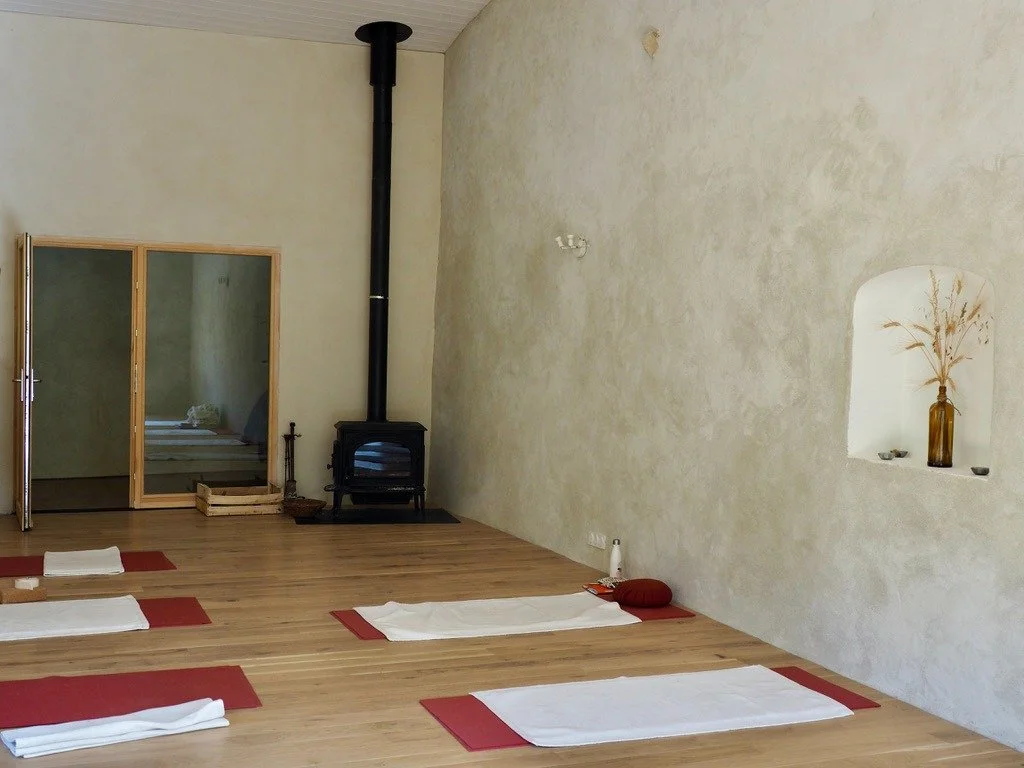Salle de pratique naturelle dans un gîte écologique en Occitanie, pensée pour stages, retraites et formations. Espace calme, matériaux respirants, lumière vivante. Location de lieu de stage yoga dans l’Aude, accessible depuis Toulouse, Montpellier et