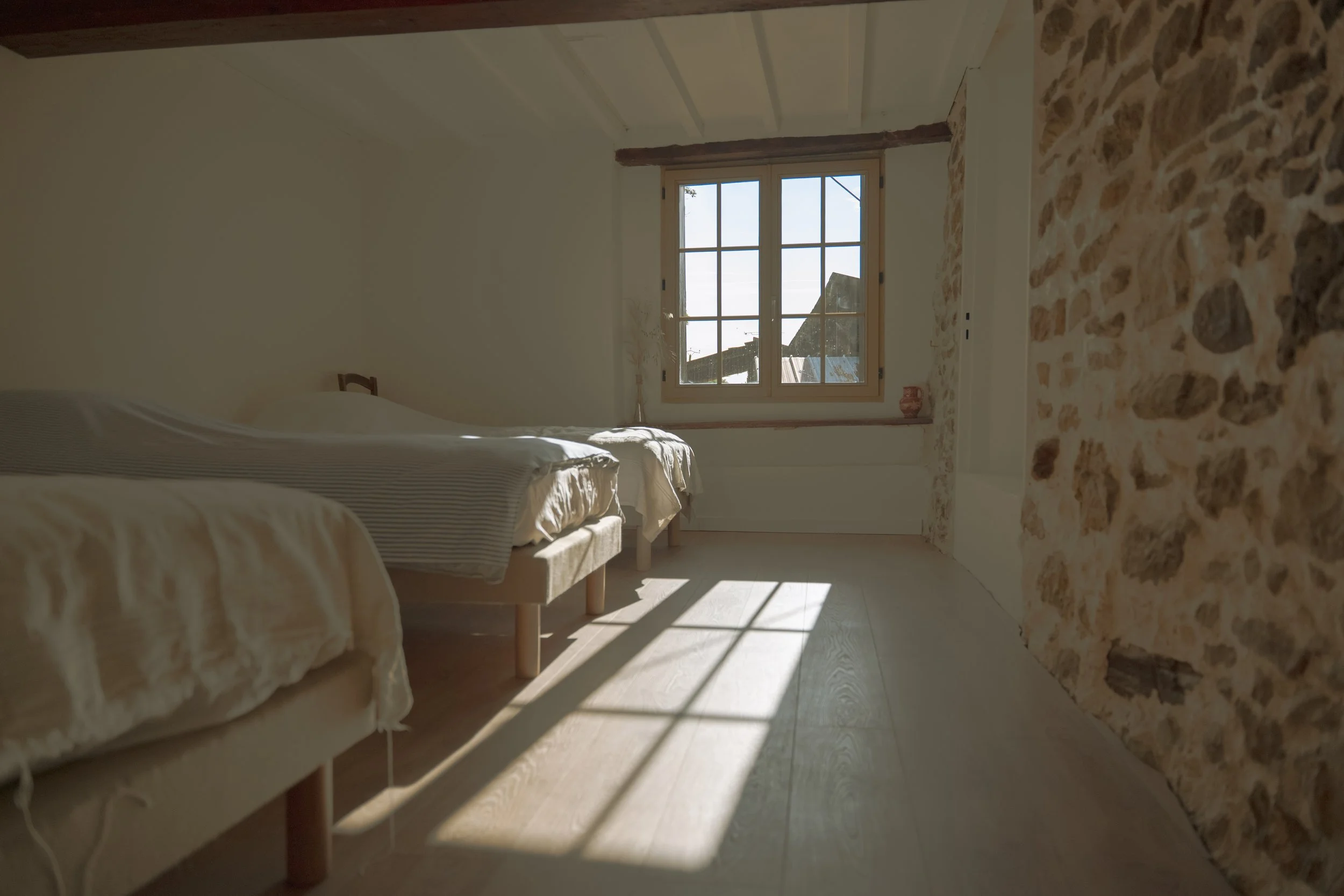Chambre calme d’un écolieu rural en Occitanie, dédiée aux séjours collectifs, stages yoga et retraites bien-être. Air sain, murs en chaux, literie respirante. Location de gîte de groupe dans l’Aude, accessible depuis Toulouse, Montpellier, Ariège et 