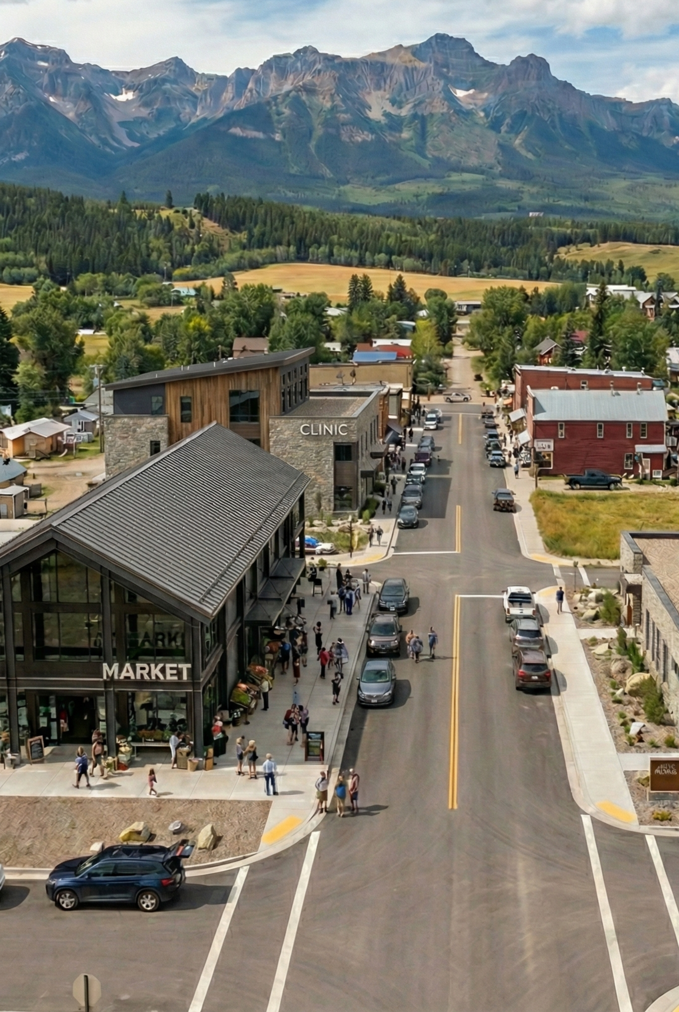A small town with a market, clinic, and people walking on the street, with a mountainous landscape and forested area in the background.