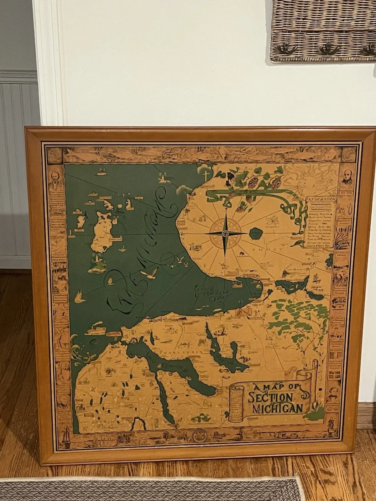 Framed vintage map of Michigan, showing its section and neighboring Great Lakes, with decorative illustrations and label 'A Map of Section Michigan'.