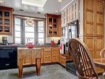Kitchen with wooden cabinets, a window above the sink, and a dining table with chairs.