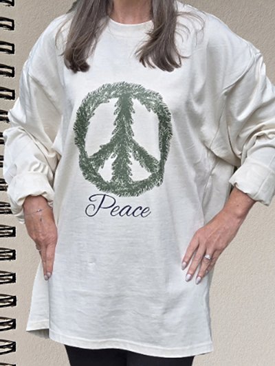 Person wearing a white oversized sweatshirt with a peace sign made of greenery and the word Peace written below.
