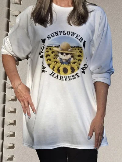 Person wearing a white oversized T-shirt with sunflower and harvest design, featuring a cartoon bunny among sunflowers, and the text 'Sunflower Harvest'.