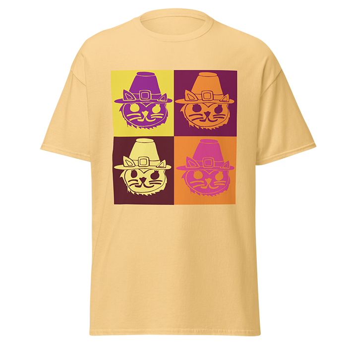 Beige T-shirt with a grid of four stylized cat faces, each wearing a pilgrim hat, in different color schemes.