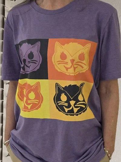 Purple T-shirt with a four-panel comic-style design of a cat face in different color schemes.
