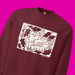 Maroon sweatshirt with a white graphic of a cat surrounded by leaves, set against a pink background.
