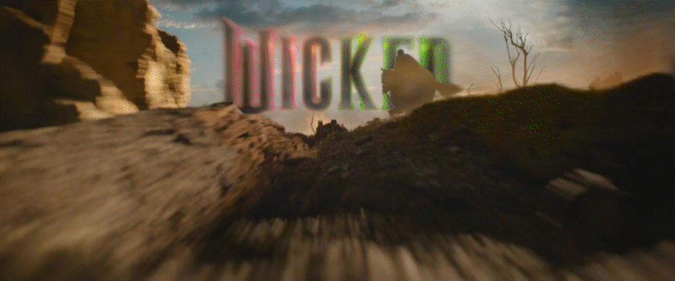 Digital glitch effect with the word "WICKED" in neon colors over a desert landscape with rocky formations and a cloudy sky.