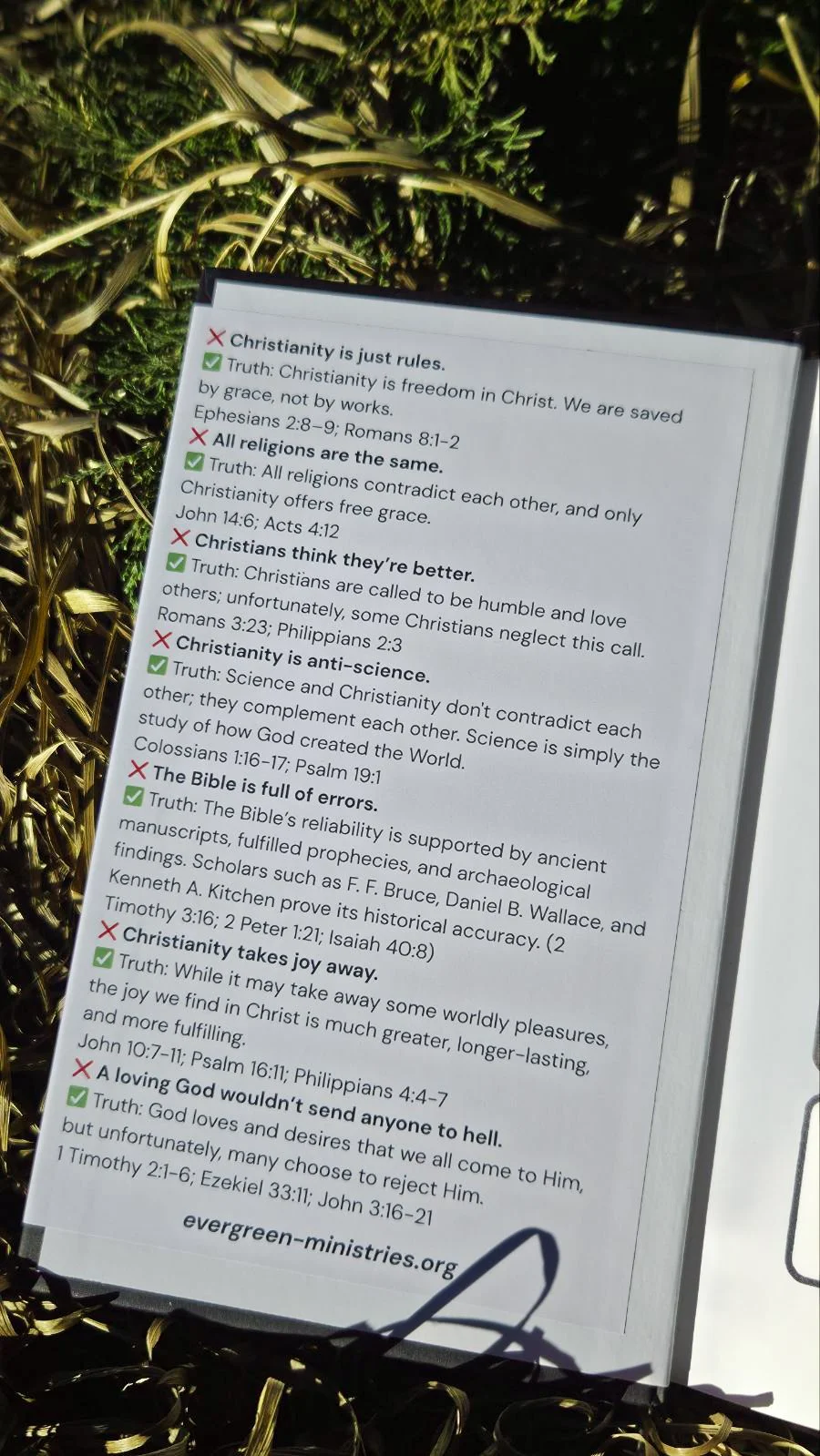 Sign with religious messages, including points about Christianity, religion, and the Bible, set against a backdrop of decorative gold and green foliage.