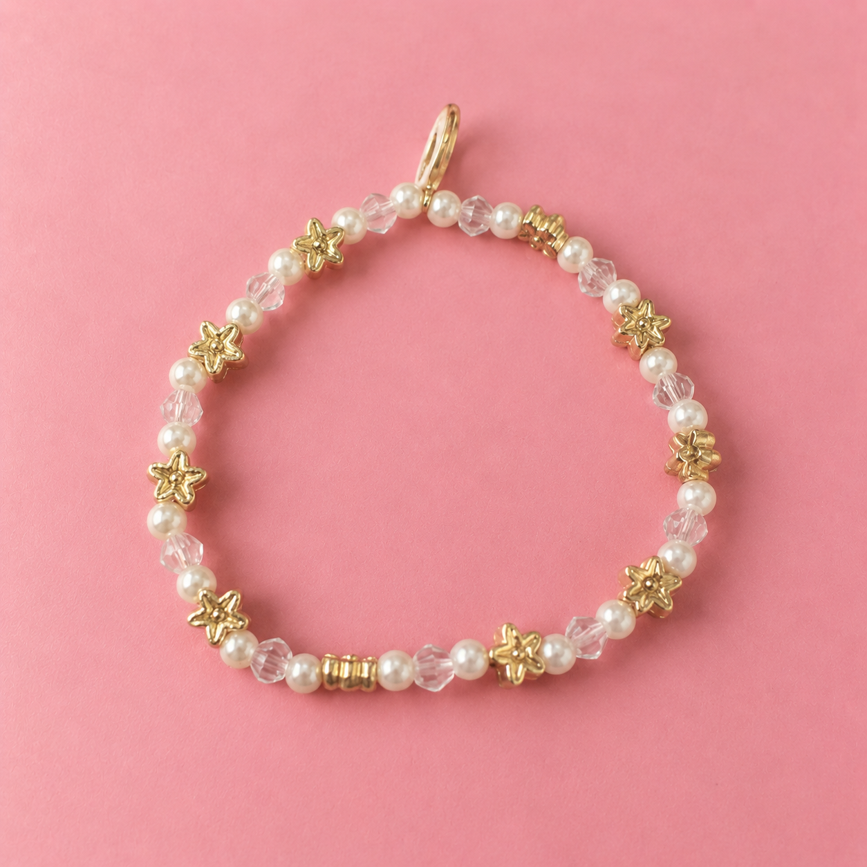 Gold and Pearl Star Bracelet on Pink.png