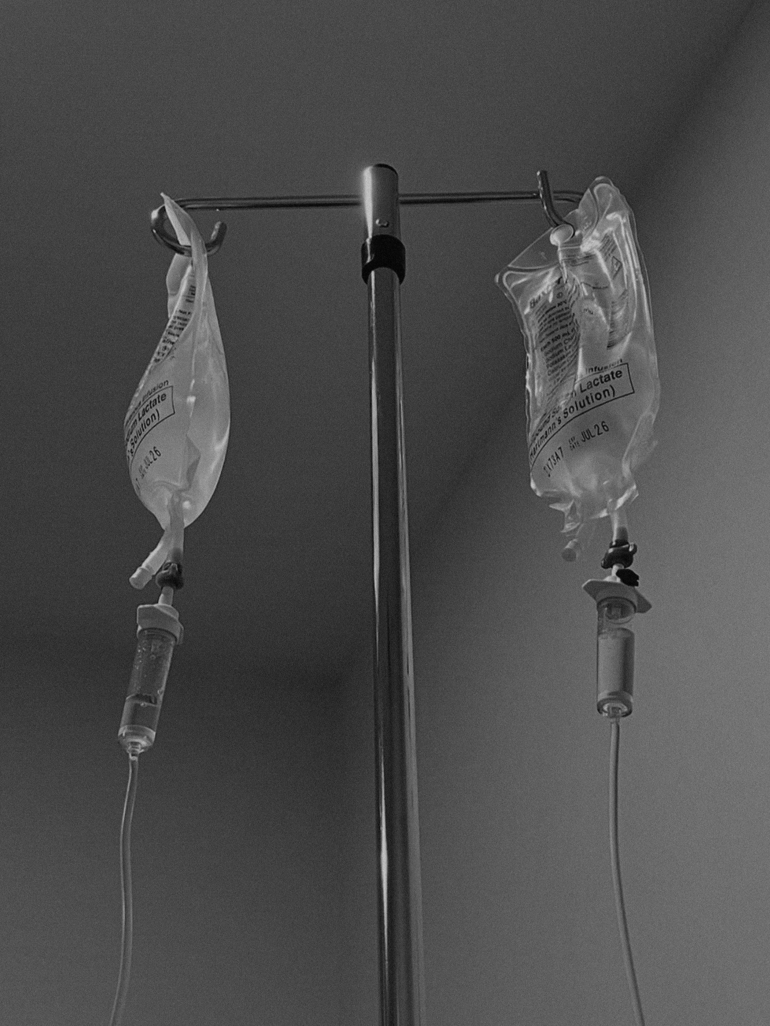 Two IV bags hanging from a stand, connected to IV tubes.