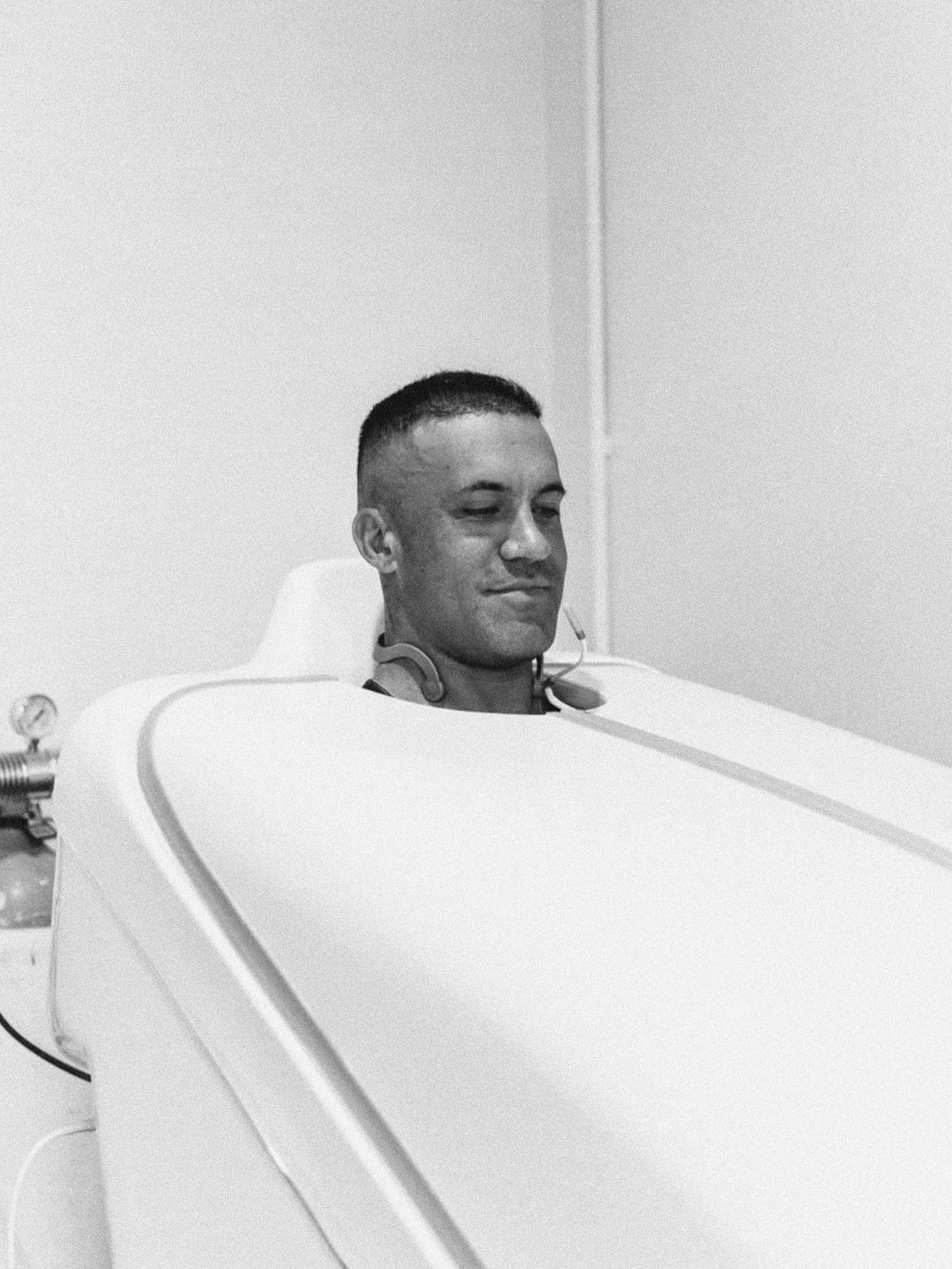 A young man undergoing a medical or scientific experiment while lying in a medical or laboratory device.