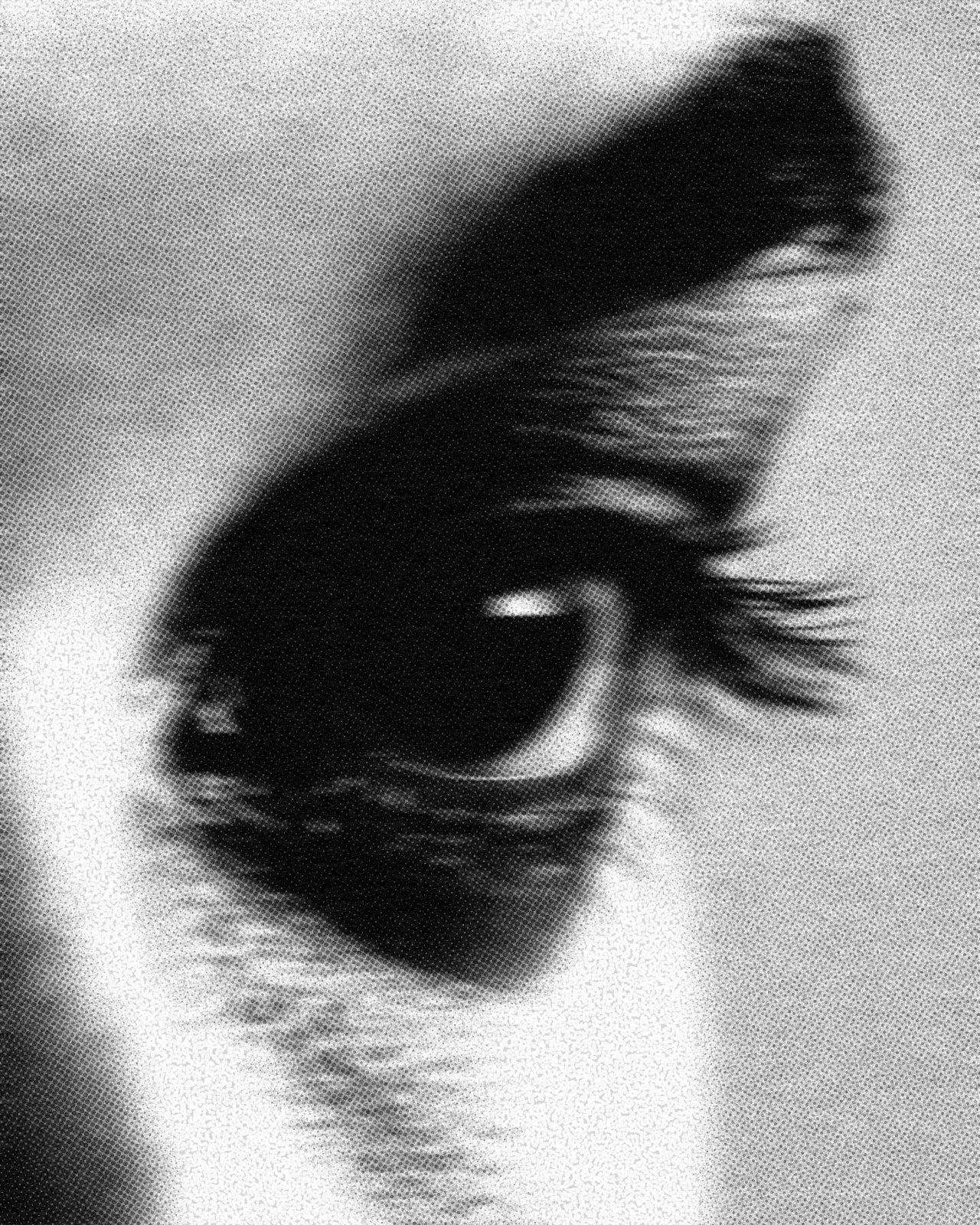 Close-up black and white photo of a human eye, displaying the eyebrow, eyelashes, and pupil.