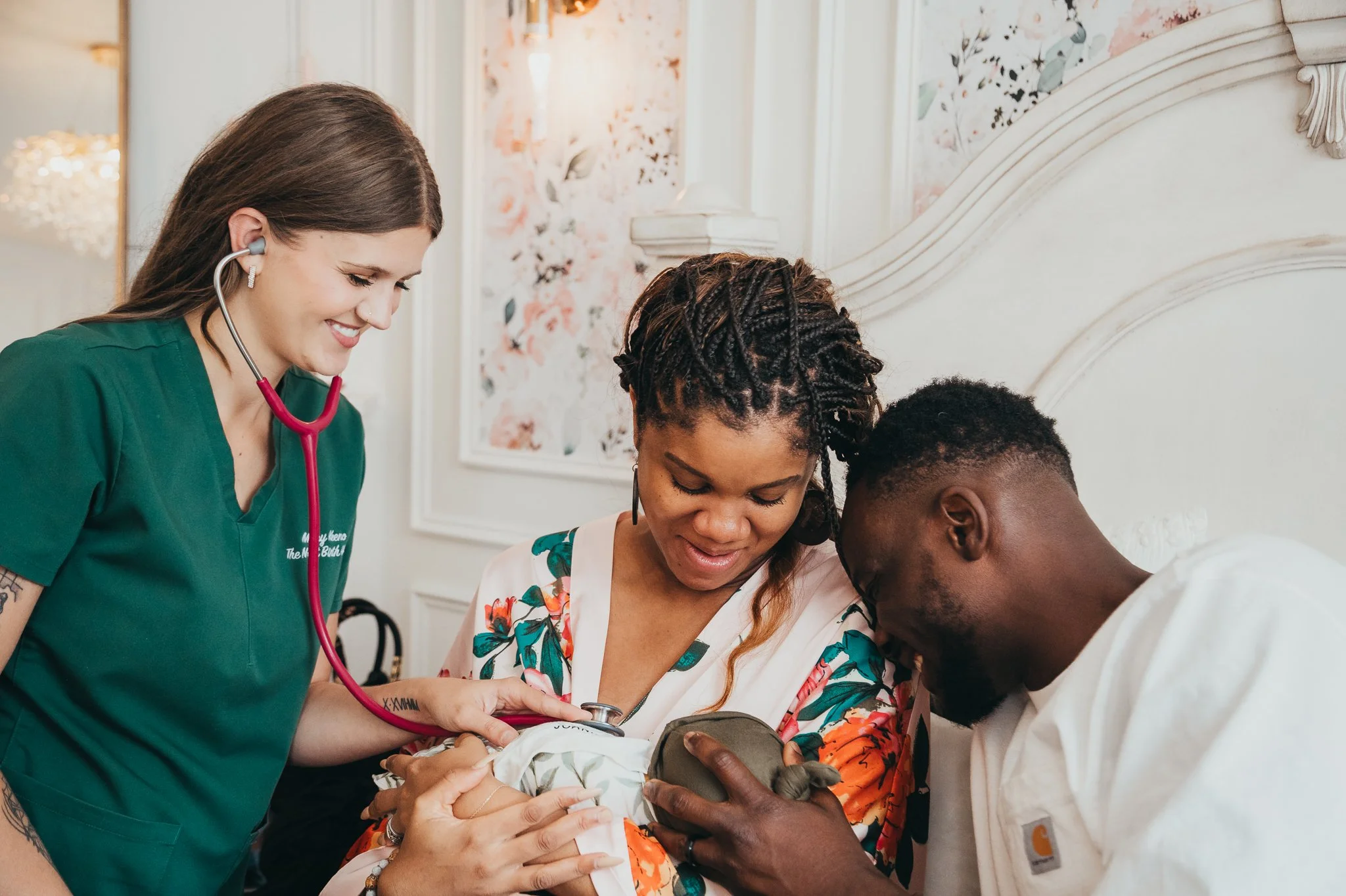 A healthcare professional with a stethoscope smiling while engaging with a mother and her newborn baby in a cozy, decorated room.