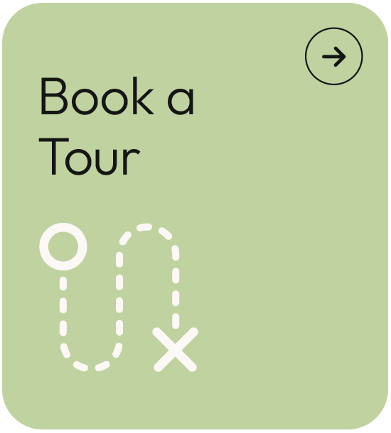Green promotional sign with black text saying "Book a Tour" and a white map marker icon with dotted lines and an 'X' indicating a route, featuring a circular arrow icon in the top right corner.