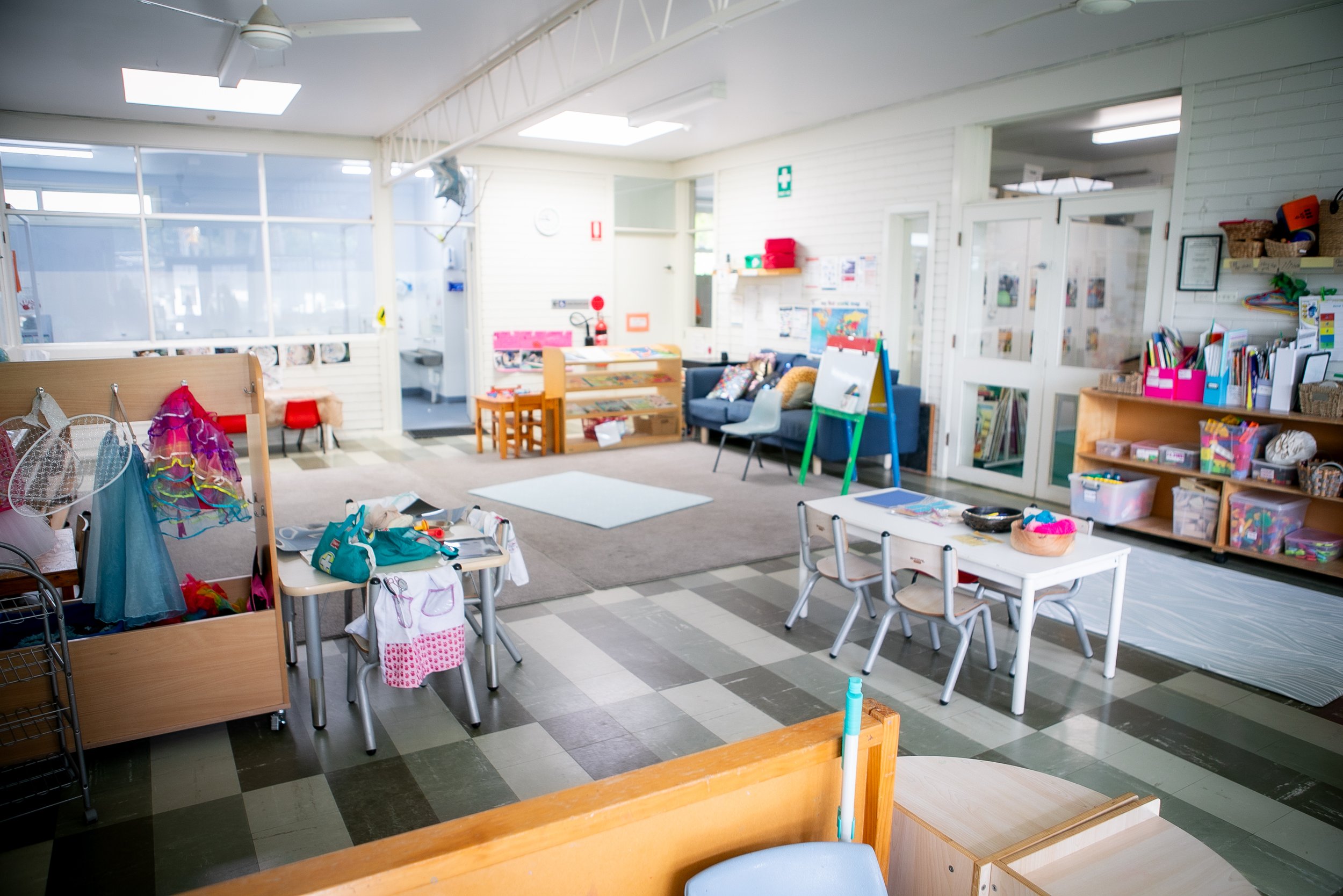 Interior of a preschool classroom with toys, furniture, and educational materials.