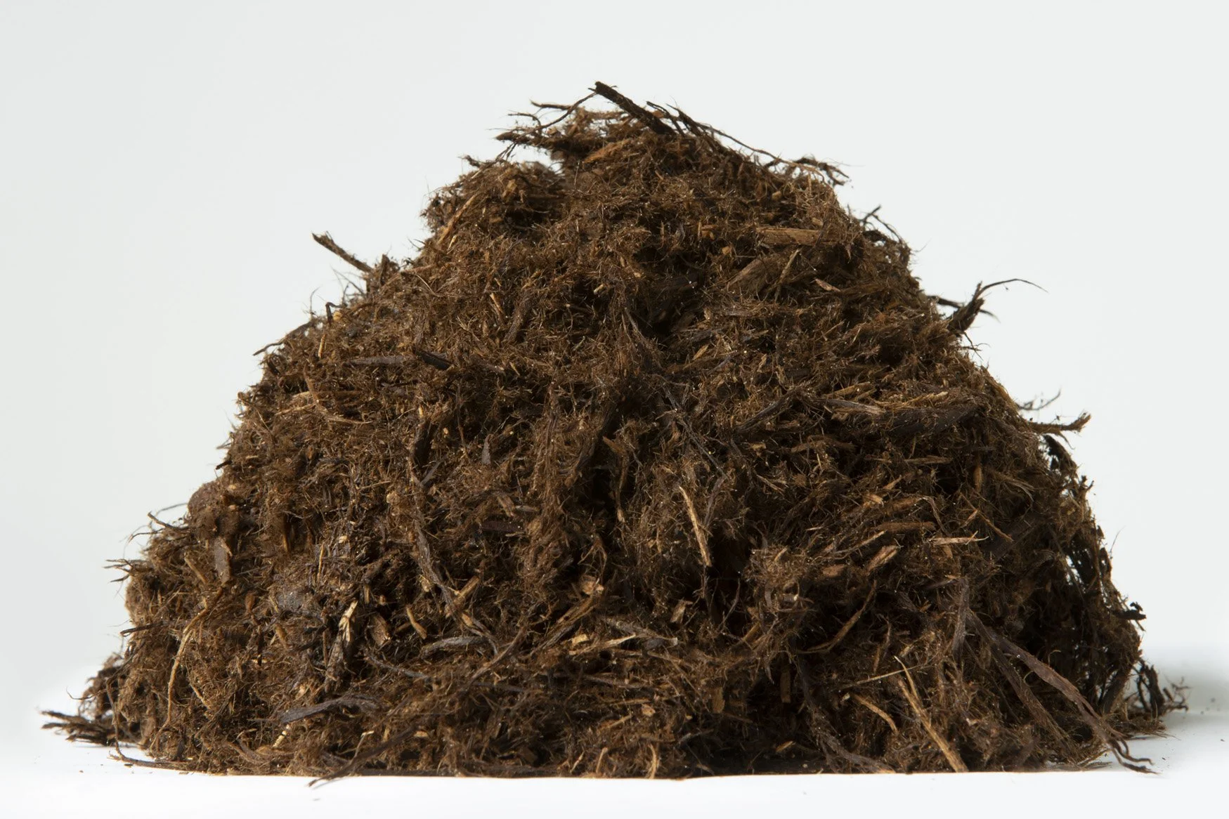 Pile of dark brown compost or soil on a plain white background.