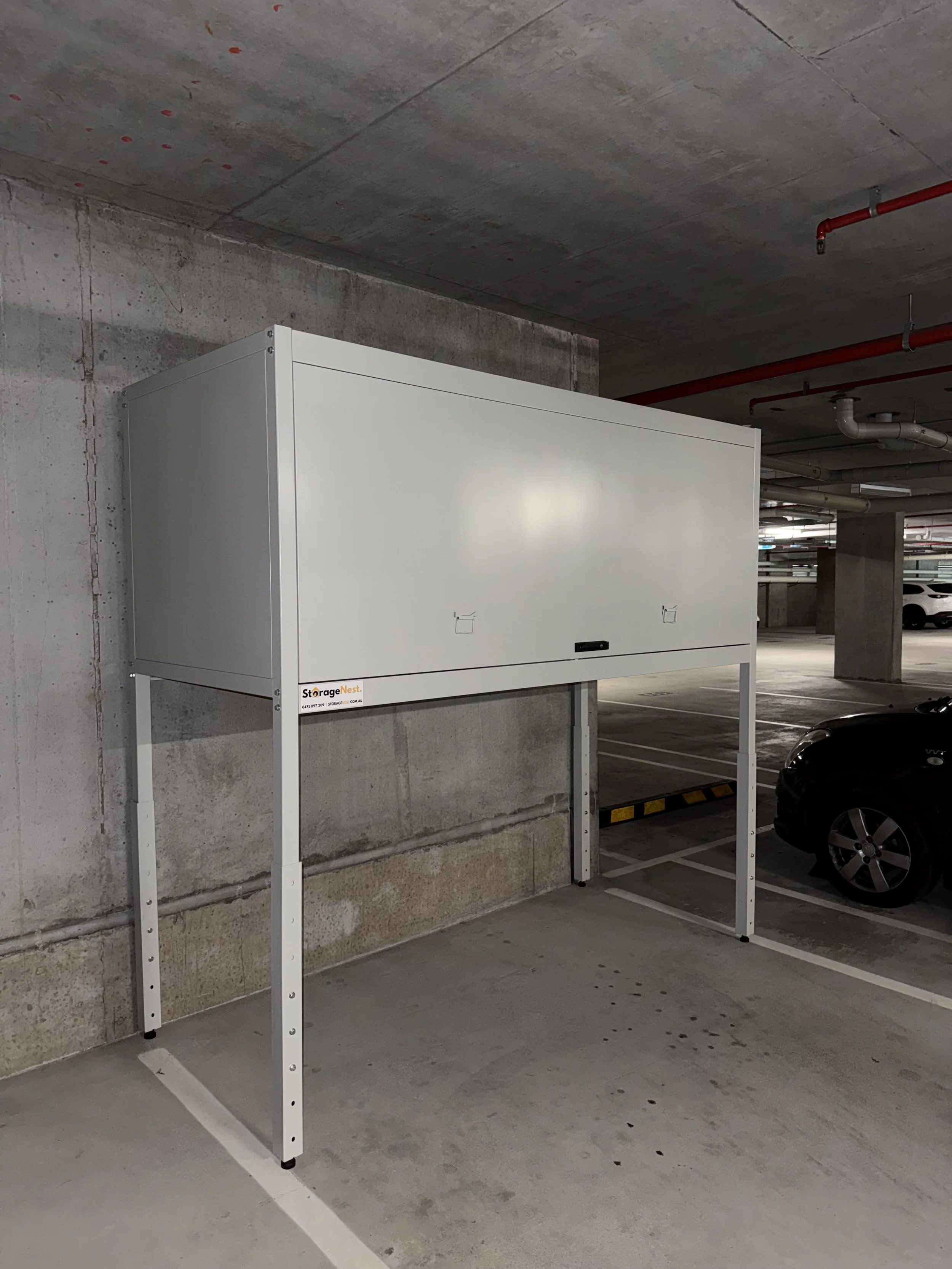 Empty whiteboard mounted on a metal stand in a parking garage.