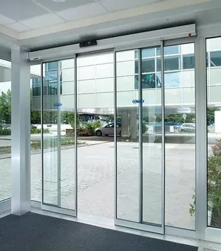 Glass sliding door with a view of cars and buildings outside.