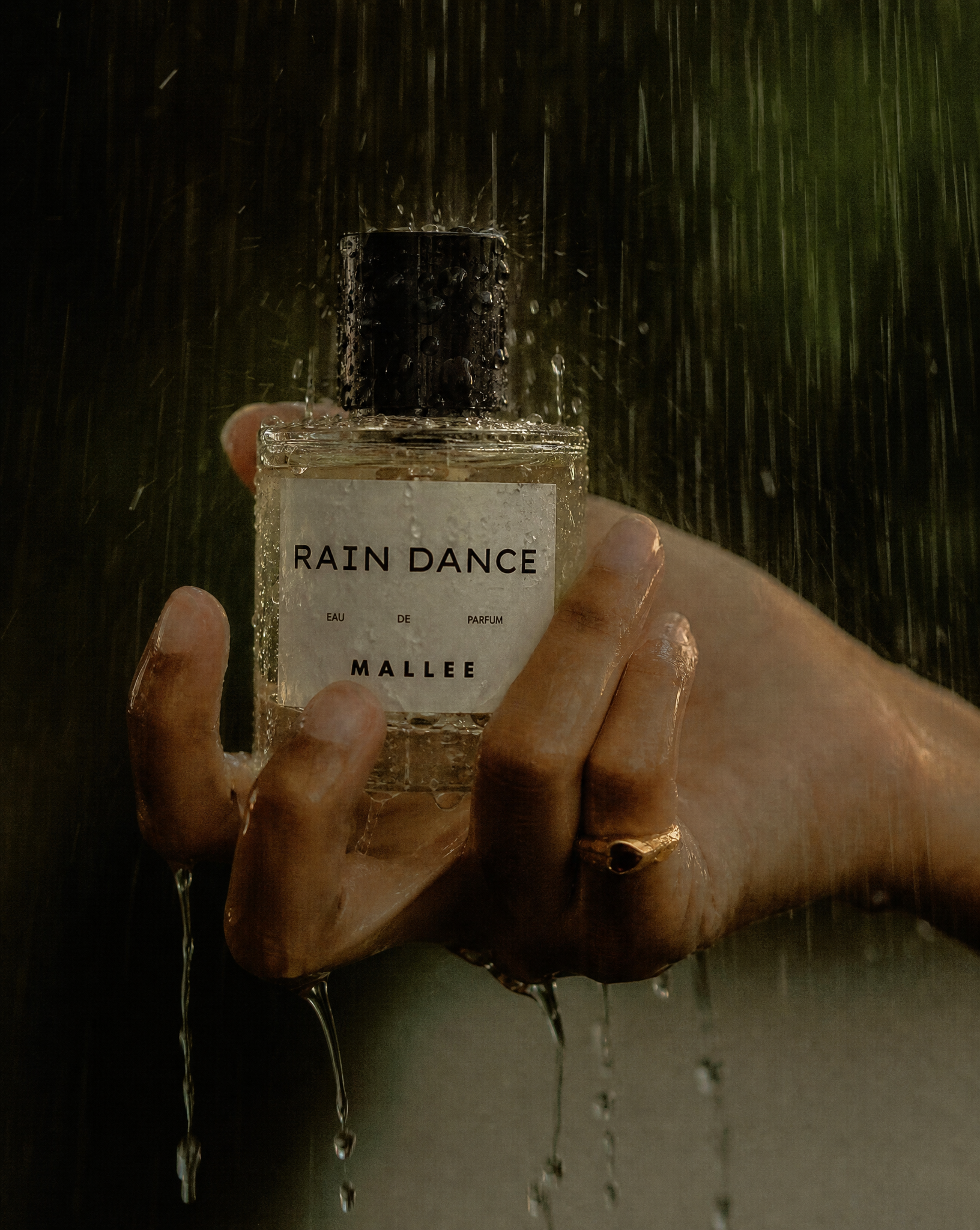 Generated with Kive.ai - Glass perfume bottle recreate a similar reference image using my perfume bottle (holding it under the rain).png
