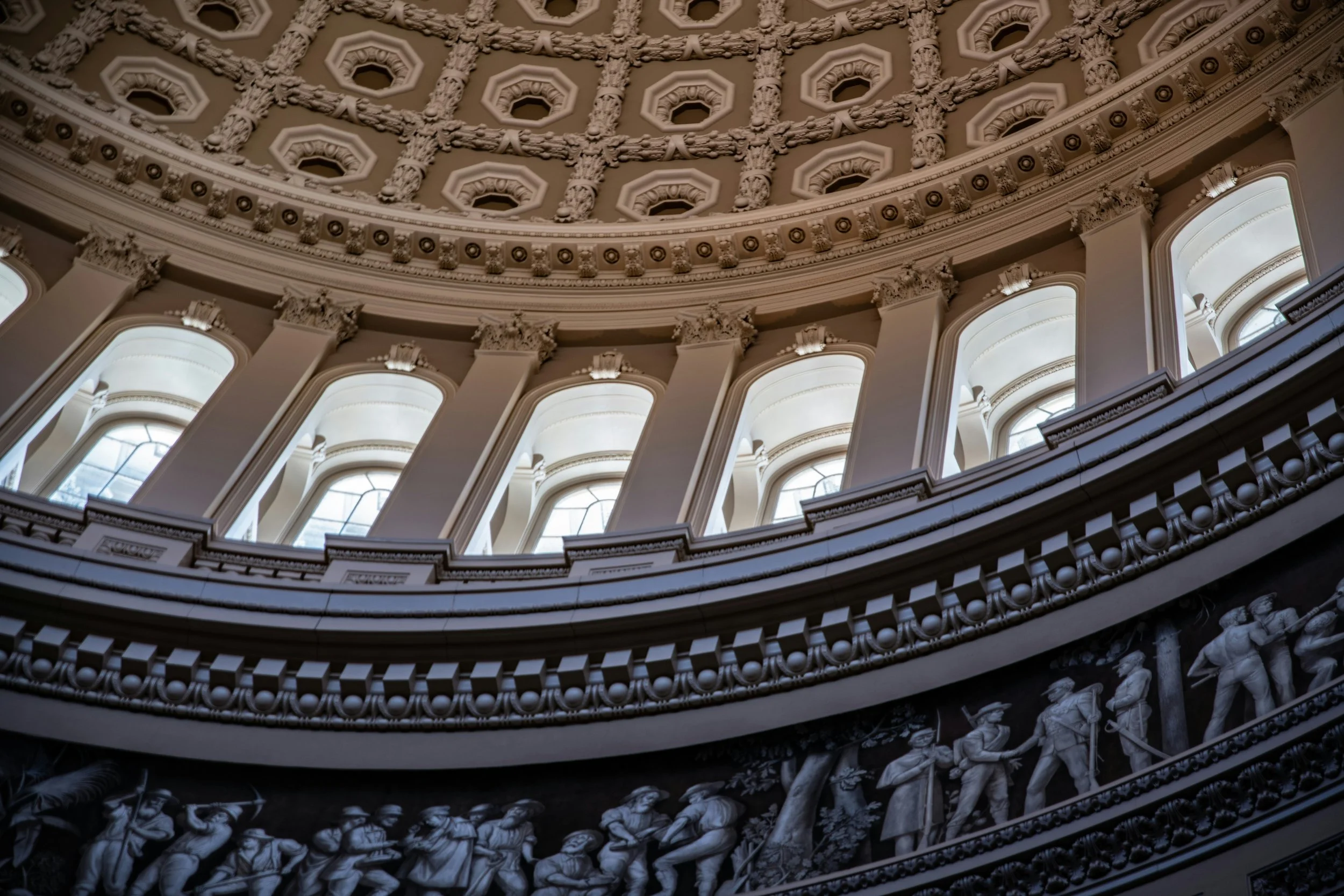 The dome of the United States Capitol building, a prominent symbol of American democracy, against a clear blue sky.