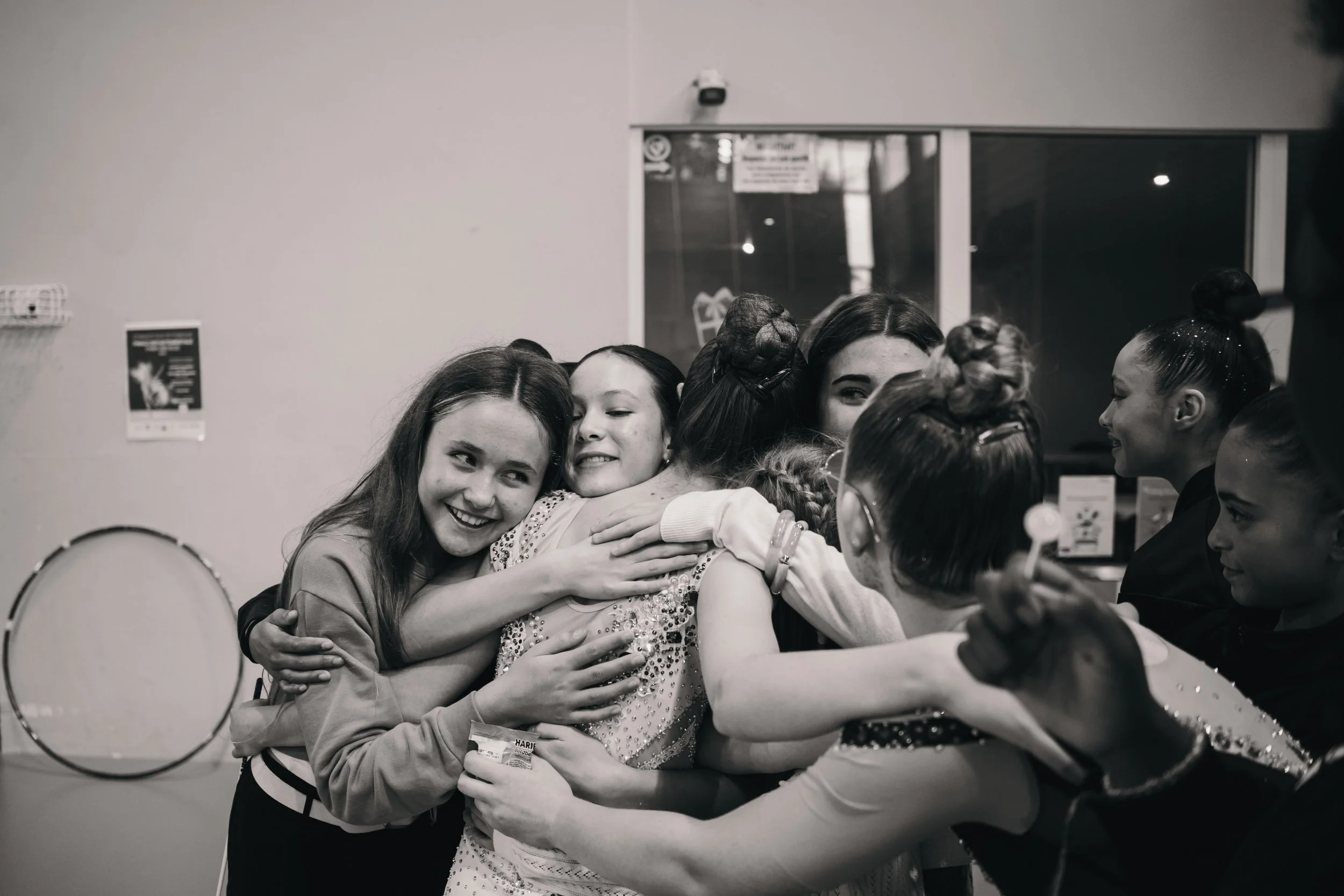 Groupe de jeunes filles souriantes en train de se faire un câlin.