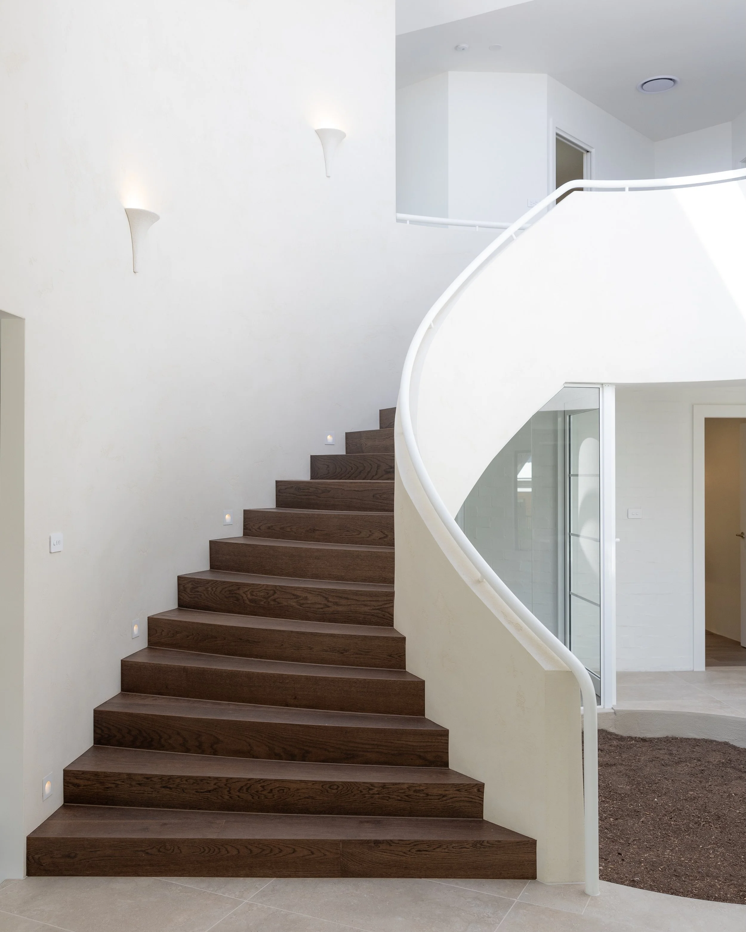 Soft curves meet rich timber - an entry that feels both sculptural and grounded in warmth.
