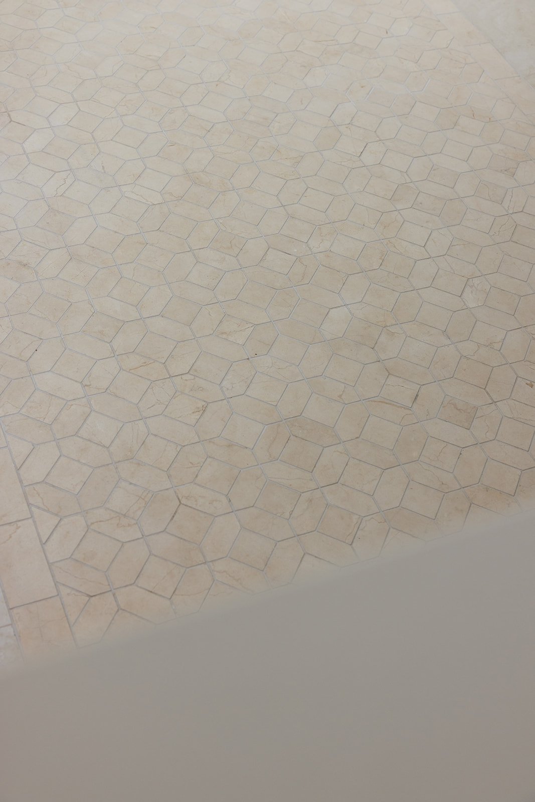Close-up of beige patterned tile floor with honeycomb shapes.