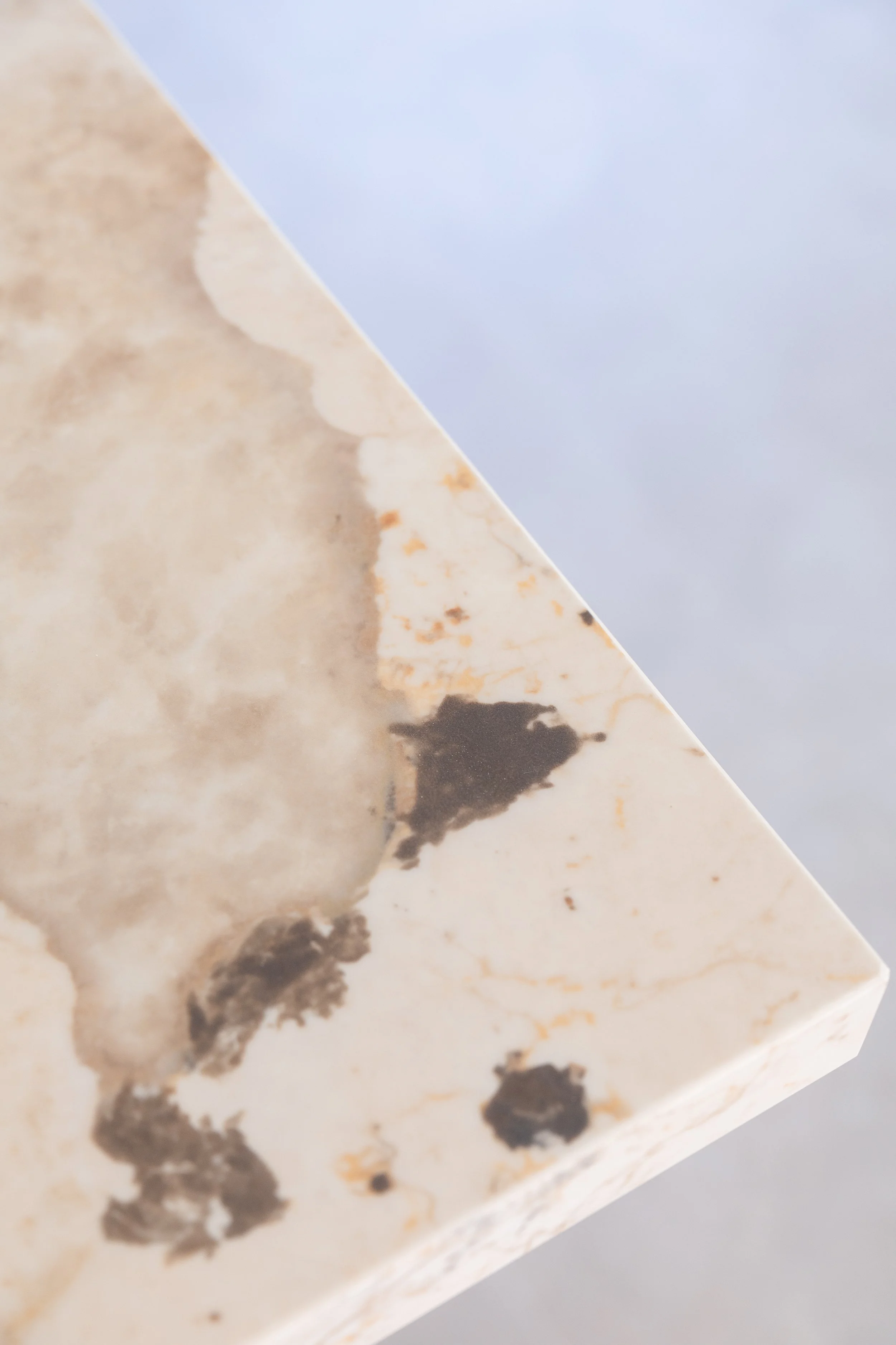 Close-up of a marble surface with natural veining and dark patches.