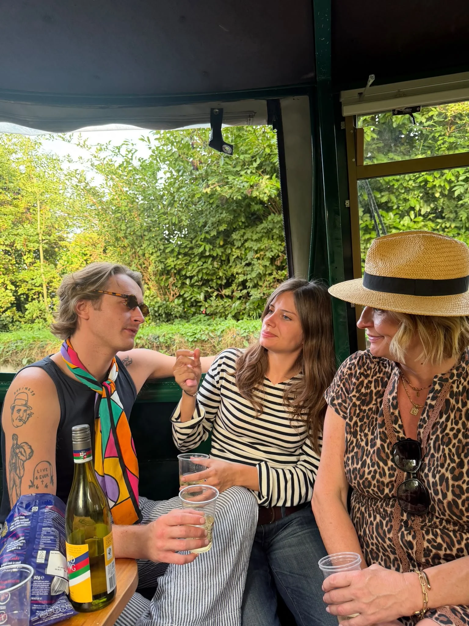 A family enjoying a drink whilst sitting inside Tilly the narrowboat during an evening hire on the Grand Union Canal in Apsley