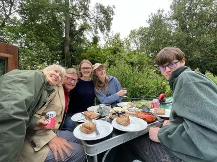 Guests relaxing together on a narrowboat during a sunny day on the Grand Union Canal.