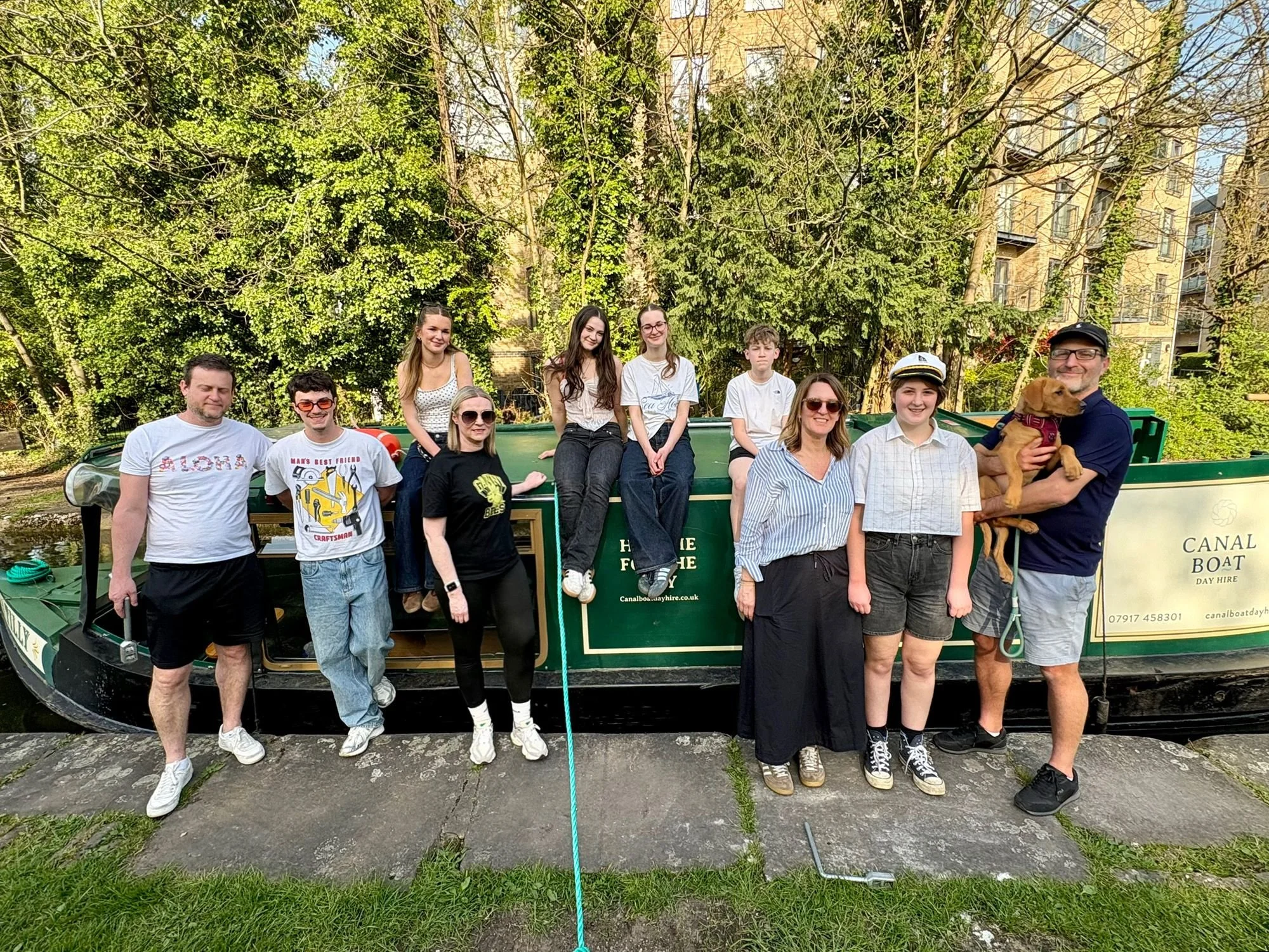 A family and their dog enjoy a day out on Tilly the narrowboat on the Grand Union Canal in Apsley