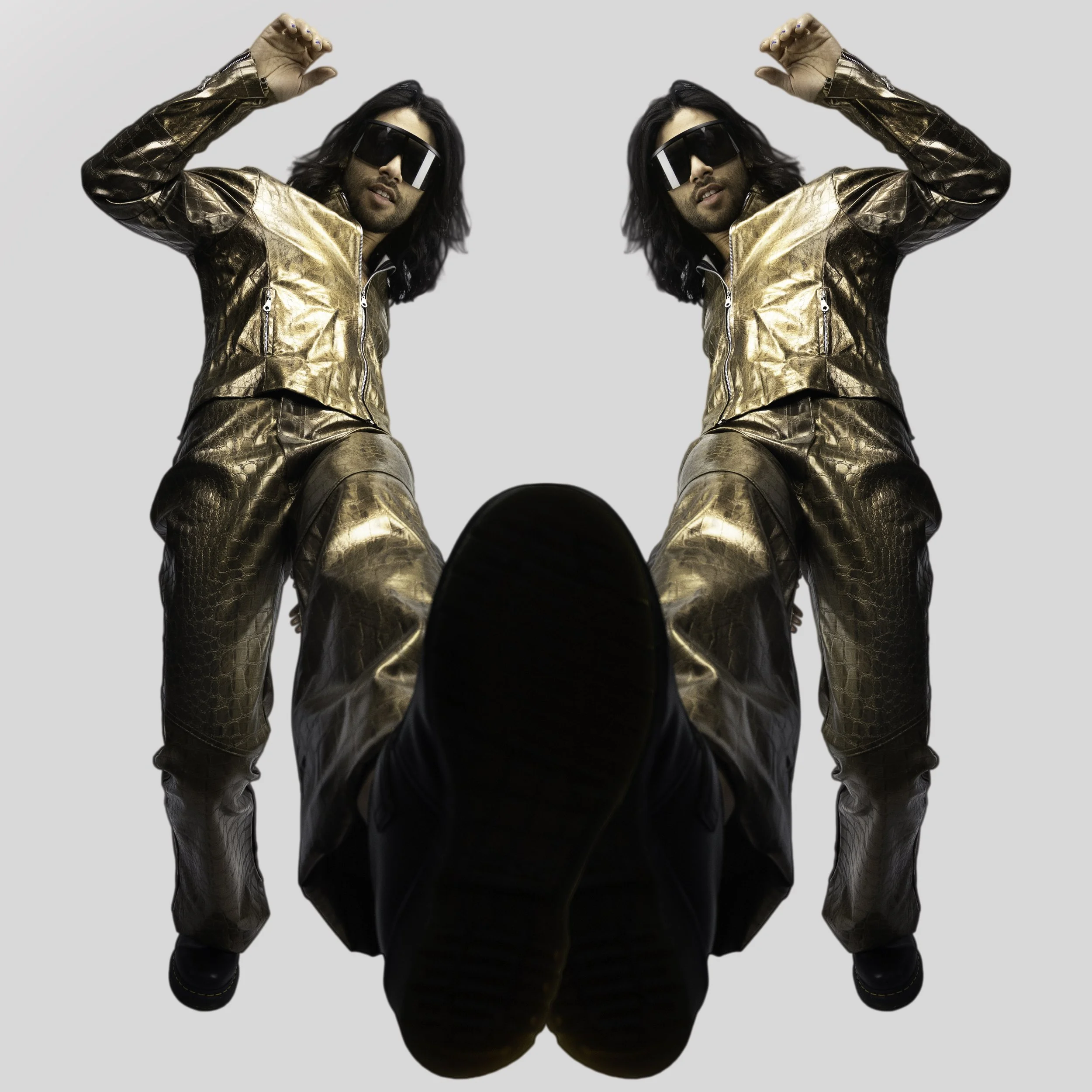 A mirrored image of a man in a gold metallic jacket and matching pants, wearing sunglasses, with one leg extended forward, capturing a confident pose against a plain background.