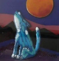 A stylized blue and white cat with spots, sitting against a colorful background with an orange sphere and mountains.