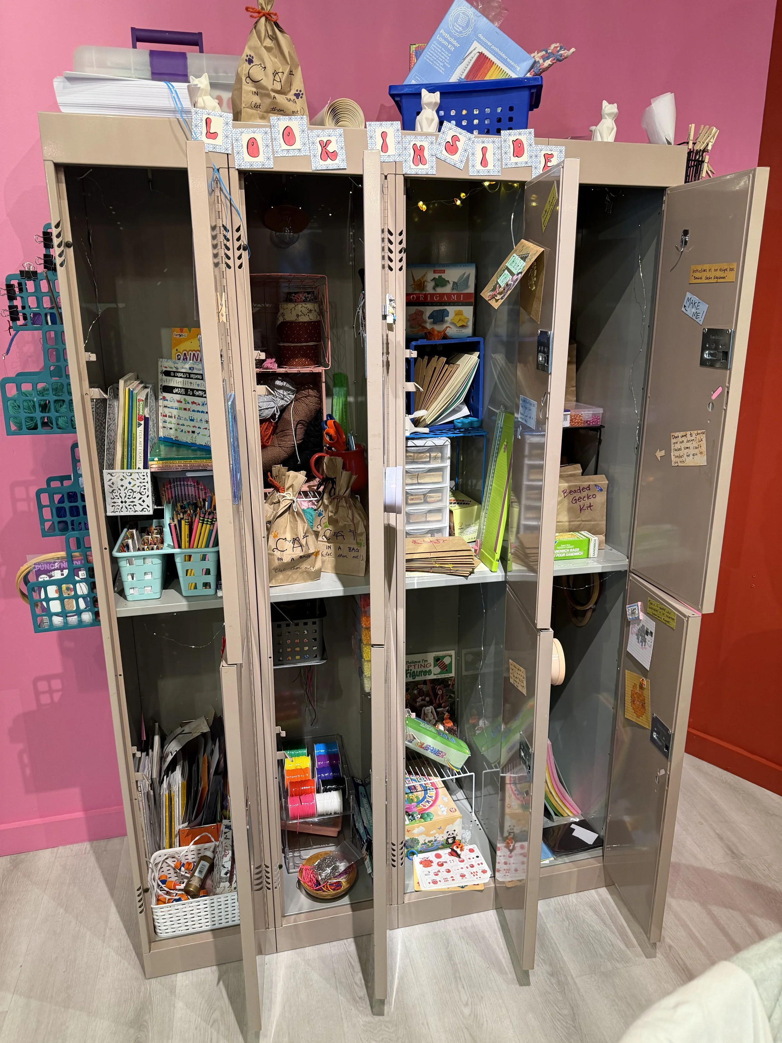 Cat People's craft closet: a bay of lockers with opened doors, showing many arts & crafts materials.