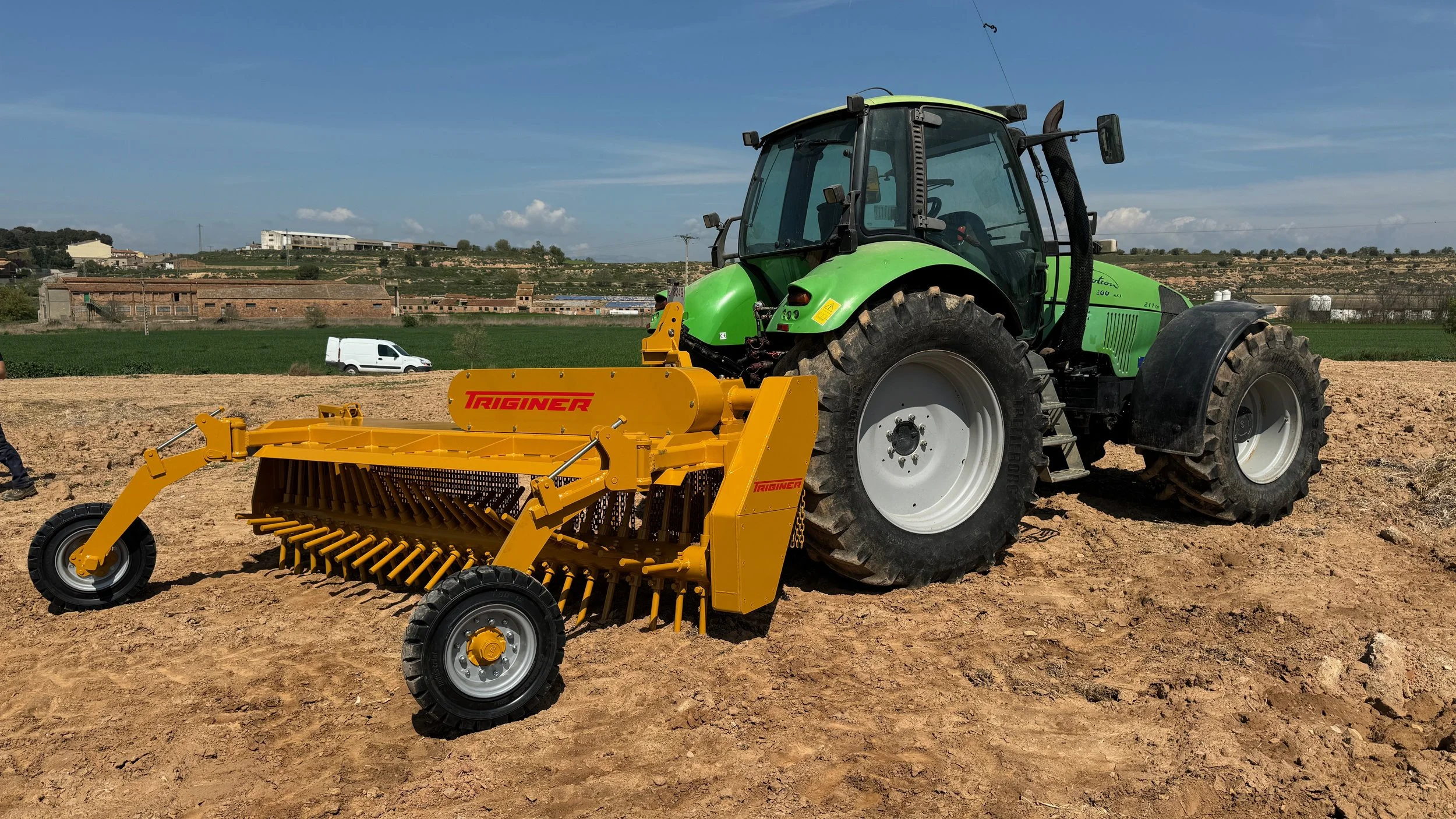 tractor con rastrillo hilerador de piedras para quitar piedras con el rastrillo