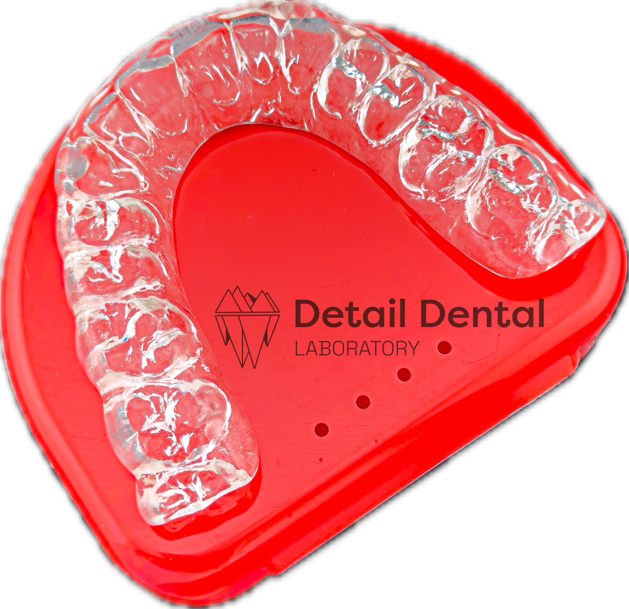 Clear dental aligner on red dental tray with logo and text 'Detail Dental Laboratory'