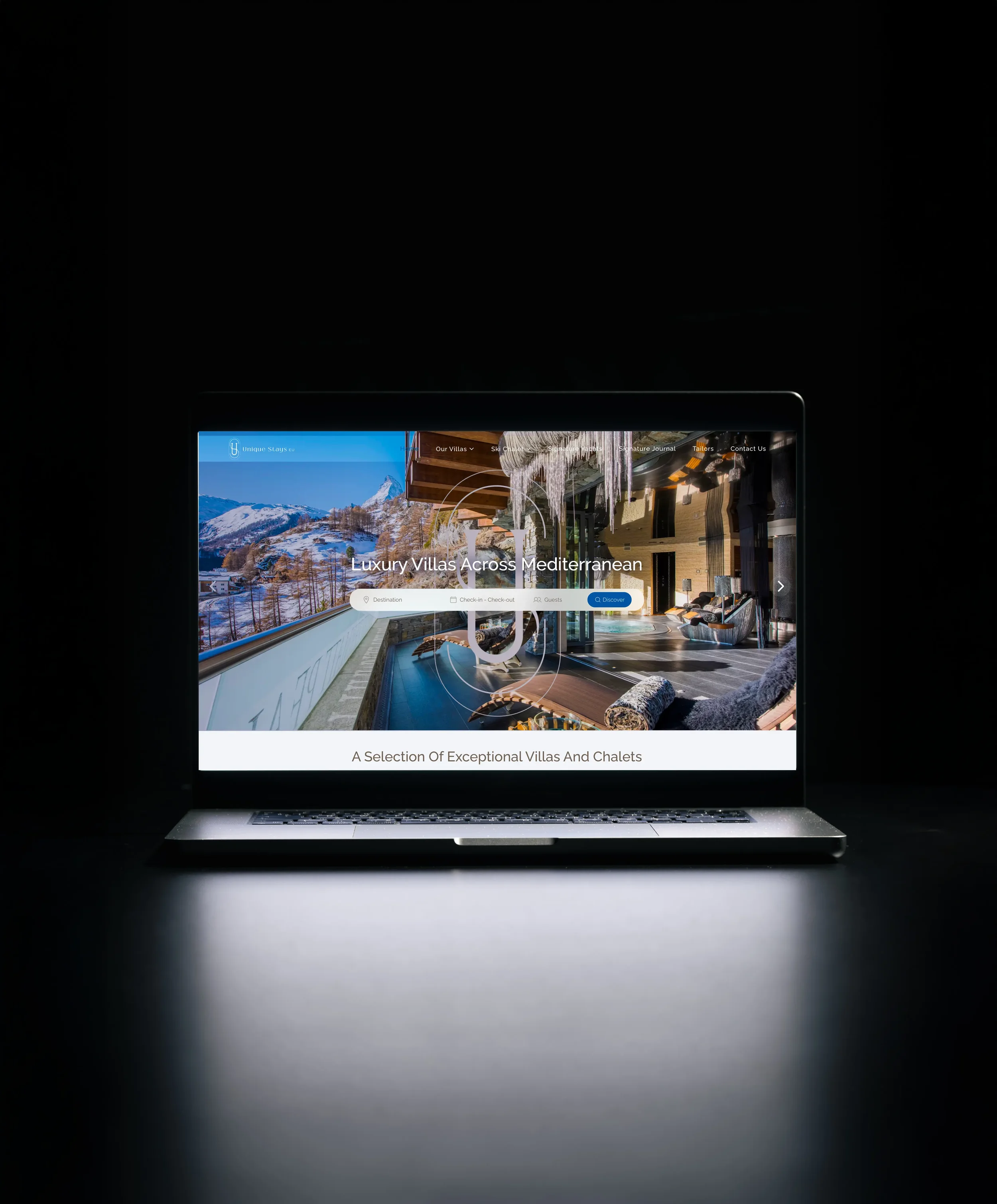 Laptop displaying a website for luxury villas in the Mediterranean with images of a mountain landscape and an interior of a villa.