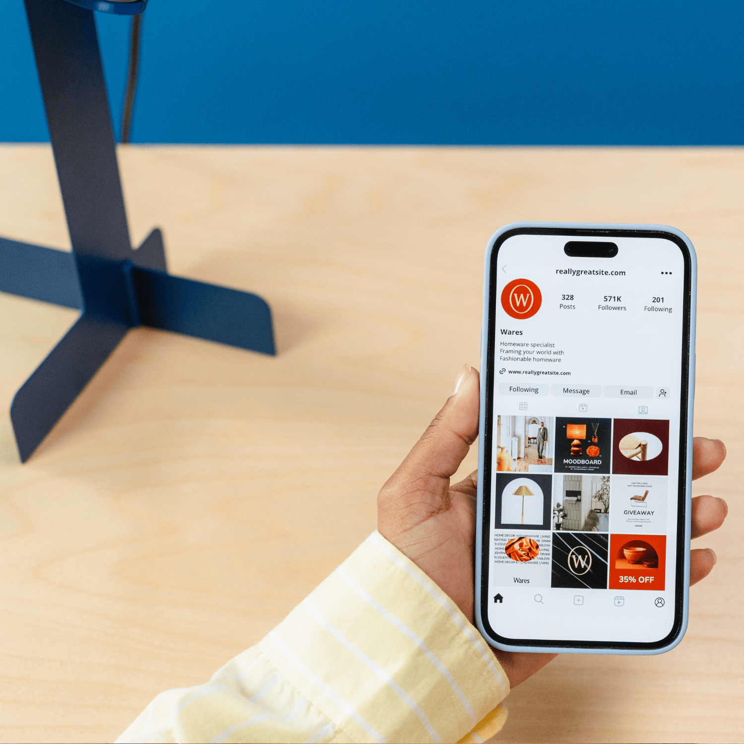 A person holding a smartphone displaying an Instagram profile called 'Really Great Site' with various home decor images and a 35% off promotion.