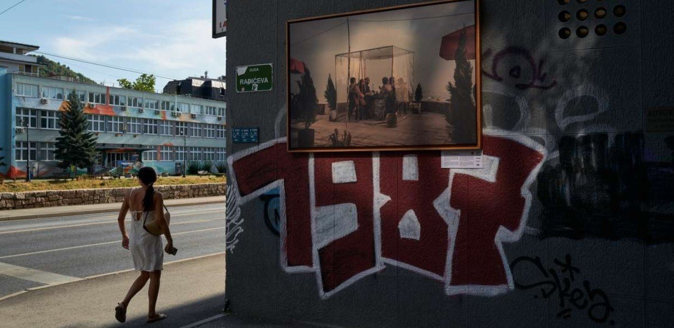 A woman walks past a large photo on display depicting people in Syria following the fall of Bashar al-Assad on July 13, 2025 in Sarajevo, Bosnia and Herzegovina. (Photo by Pierre Crom/Getty Images)