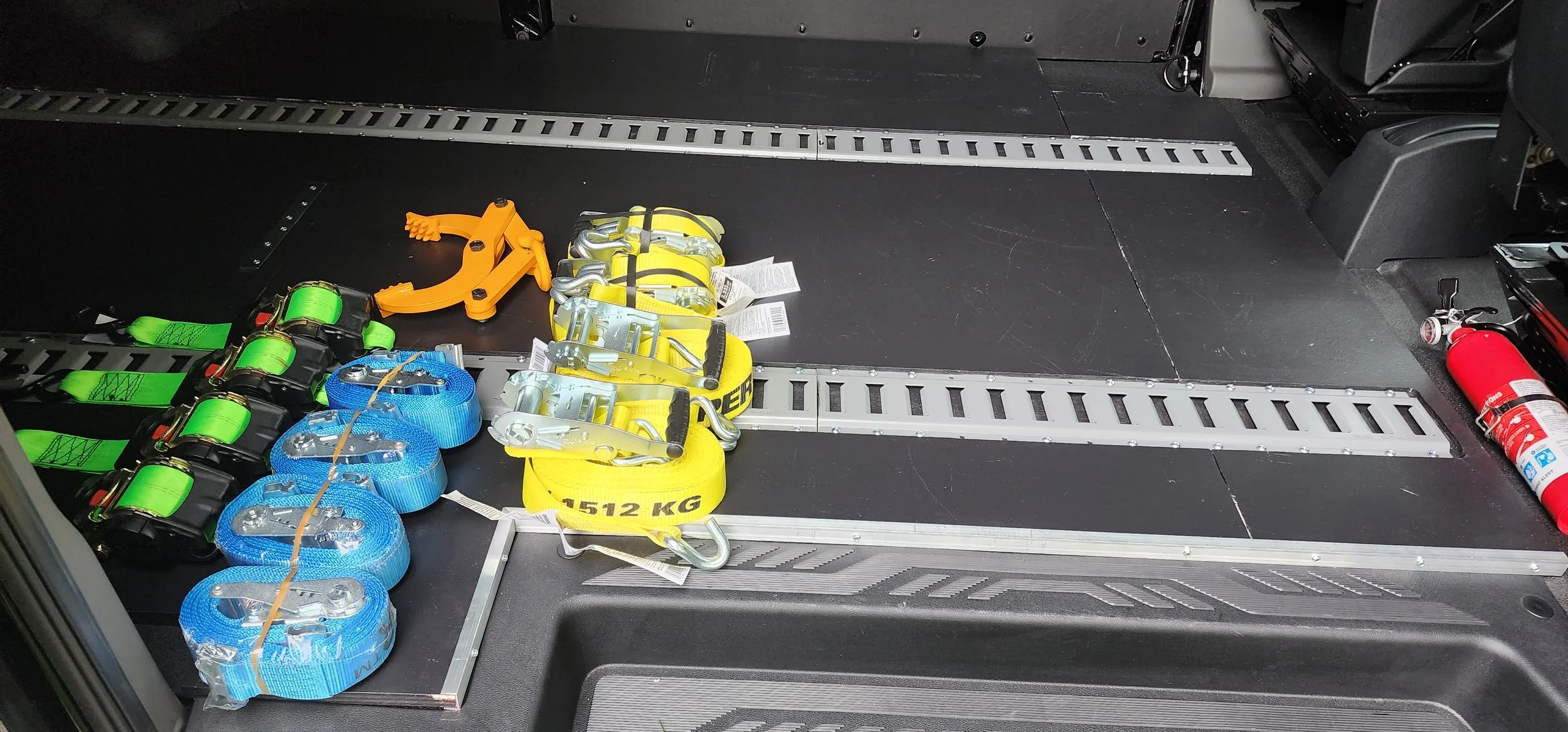 Emergency rescue equipment including straps, harnesses, and a fire extinguisher stored in a vehicle.