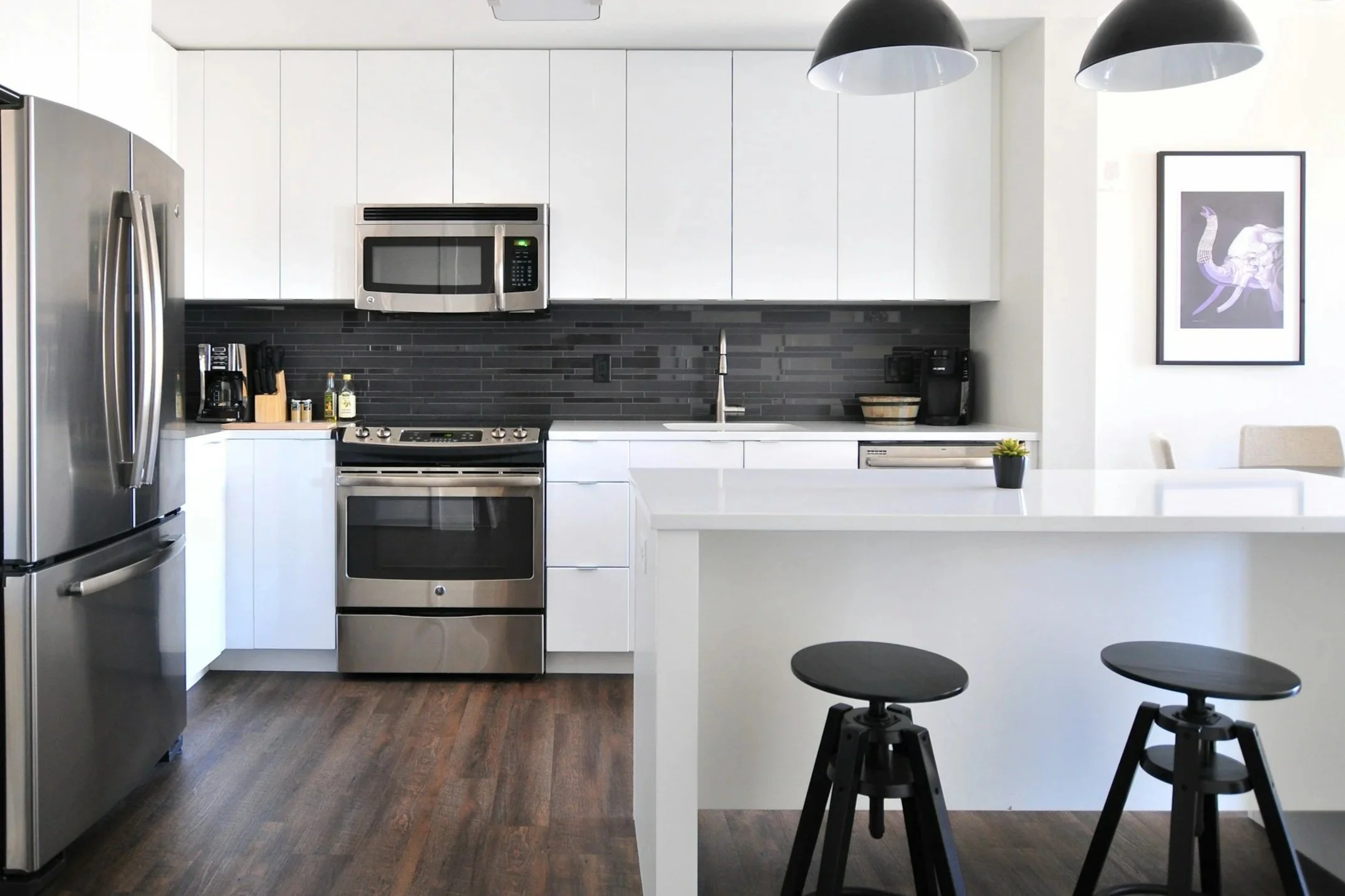 kitchen with black backsplash and white cabinets