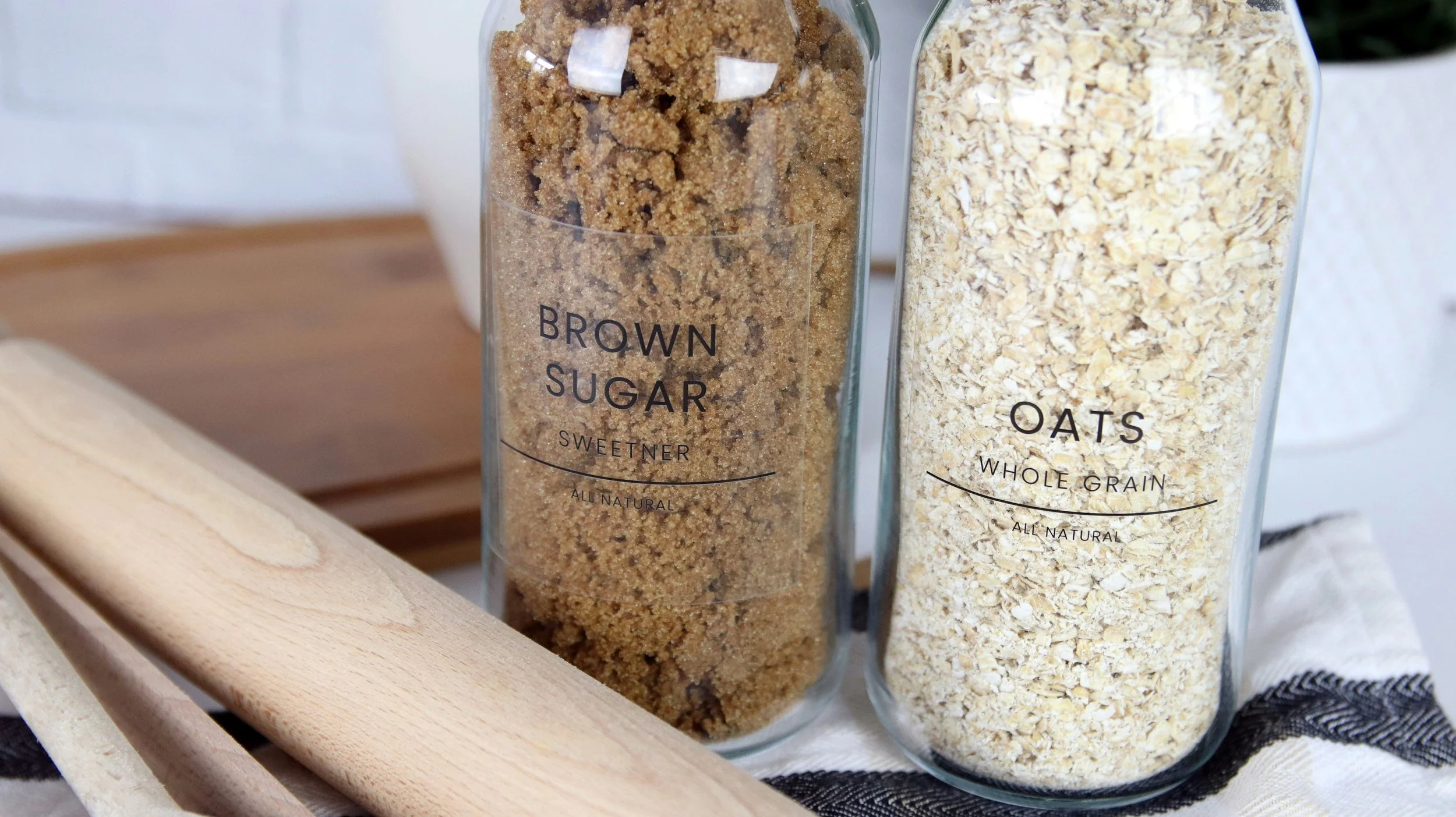 two modern glass jars with labels for brown sugar and oats