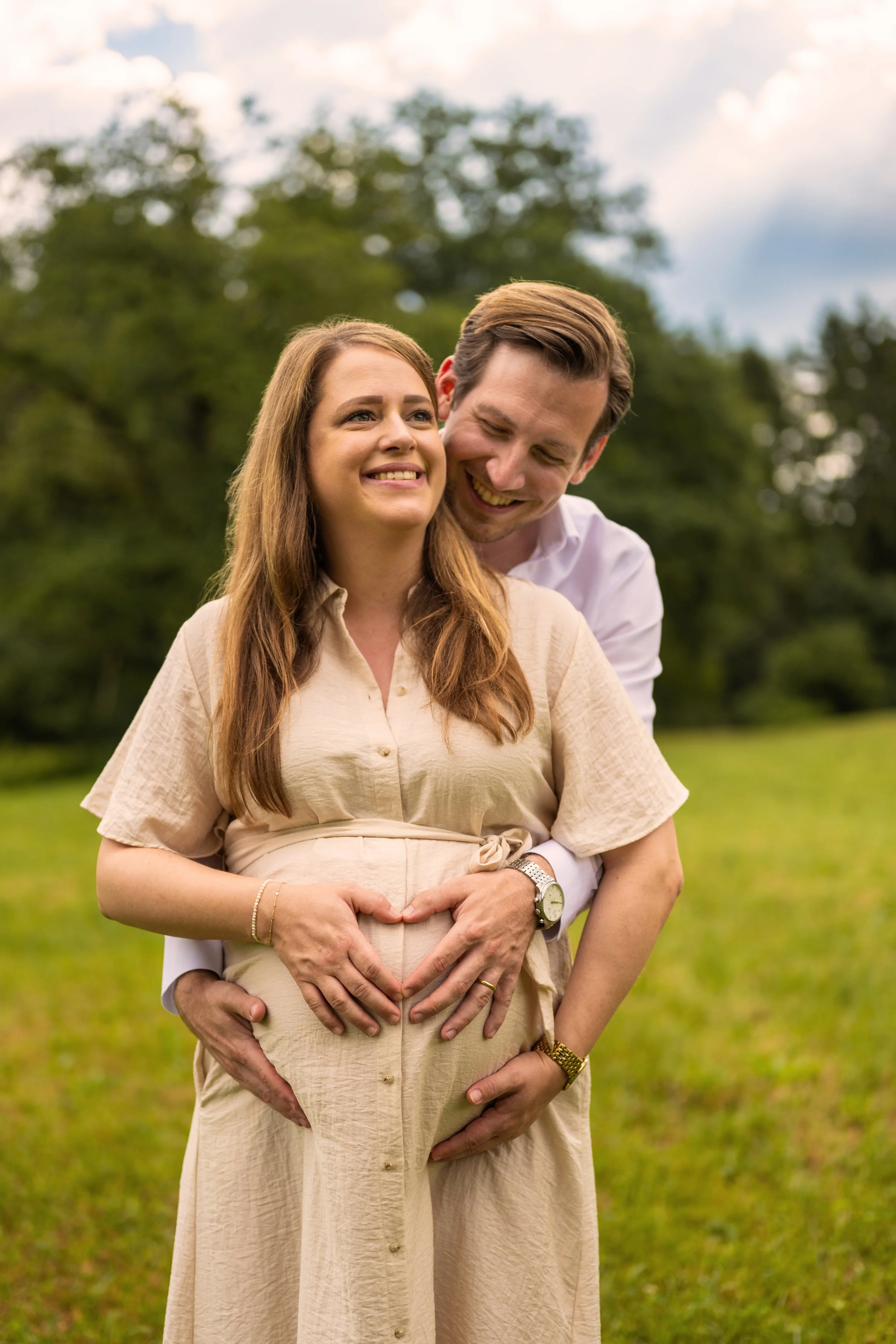 Werdende Eltern halten liebevoll den Babybauch.
