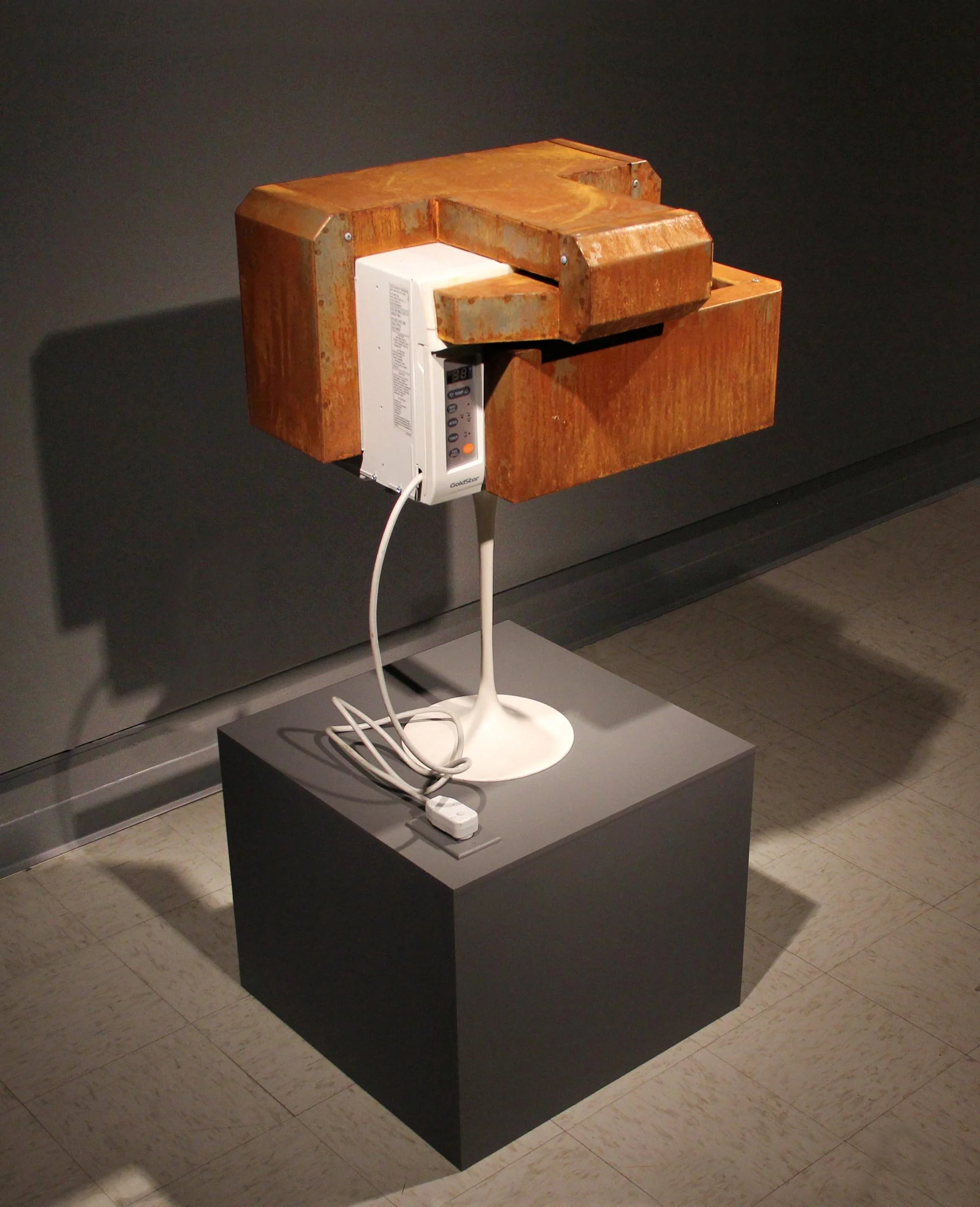 "Being Without Becoming"
24" x 27" x 56"
Air conditioner, rusted steel ducting, Eero Saarinen pedestal base, hardware. 
A window unit air conditioner cools and heats the same air over, and over, and over.
2011