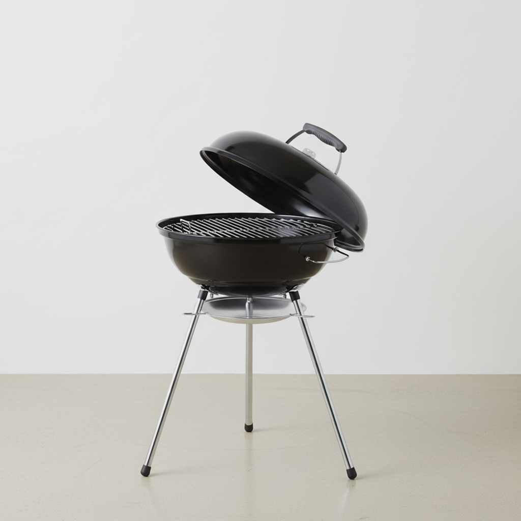 Black portable charcoal grill with lid open on a bare surface against a plain white background.
