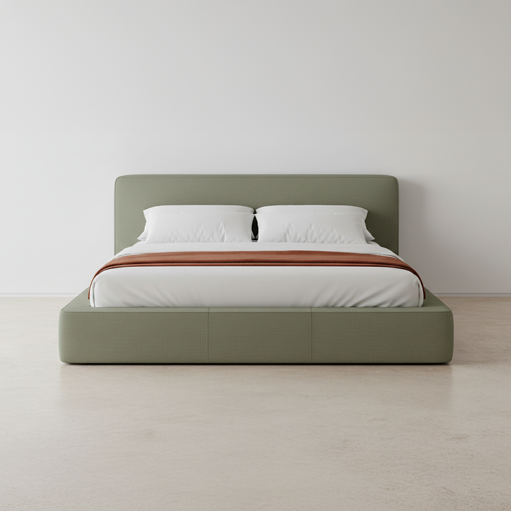 A modern bed with a green upholstered frame and headboard, white bed linens, and a brown throw blanket, against a plain white wall.